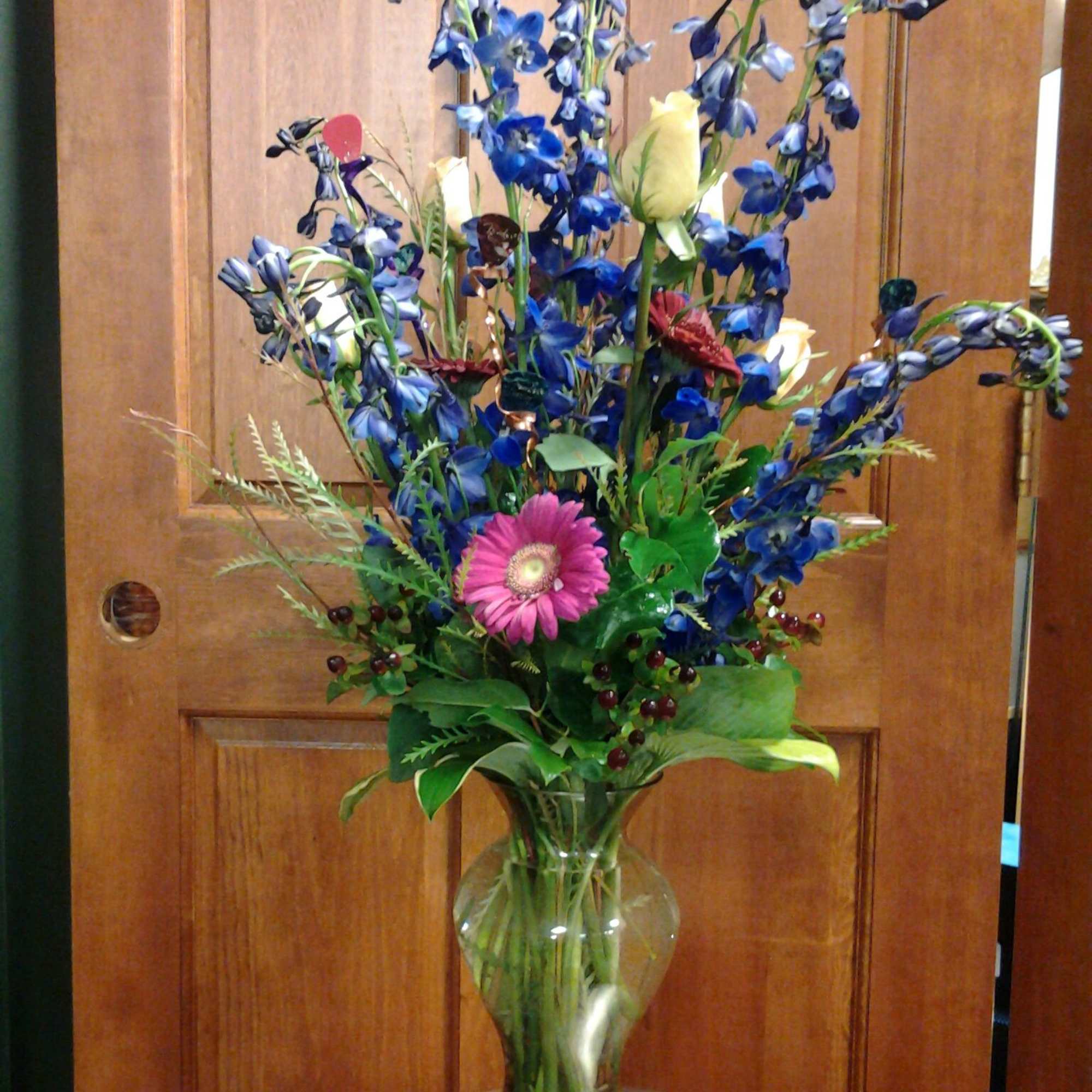 With a mixture of roses, asters, other flowers along with some bling