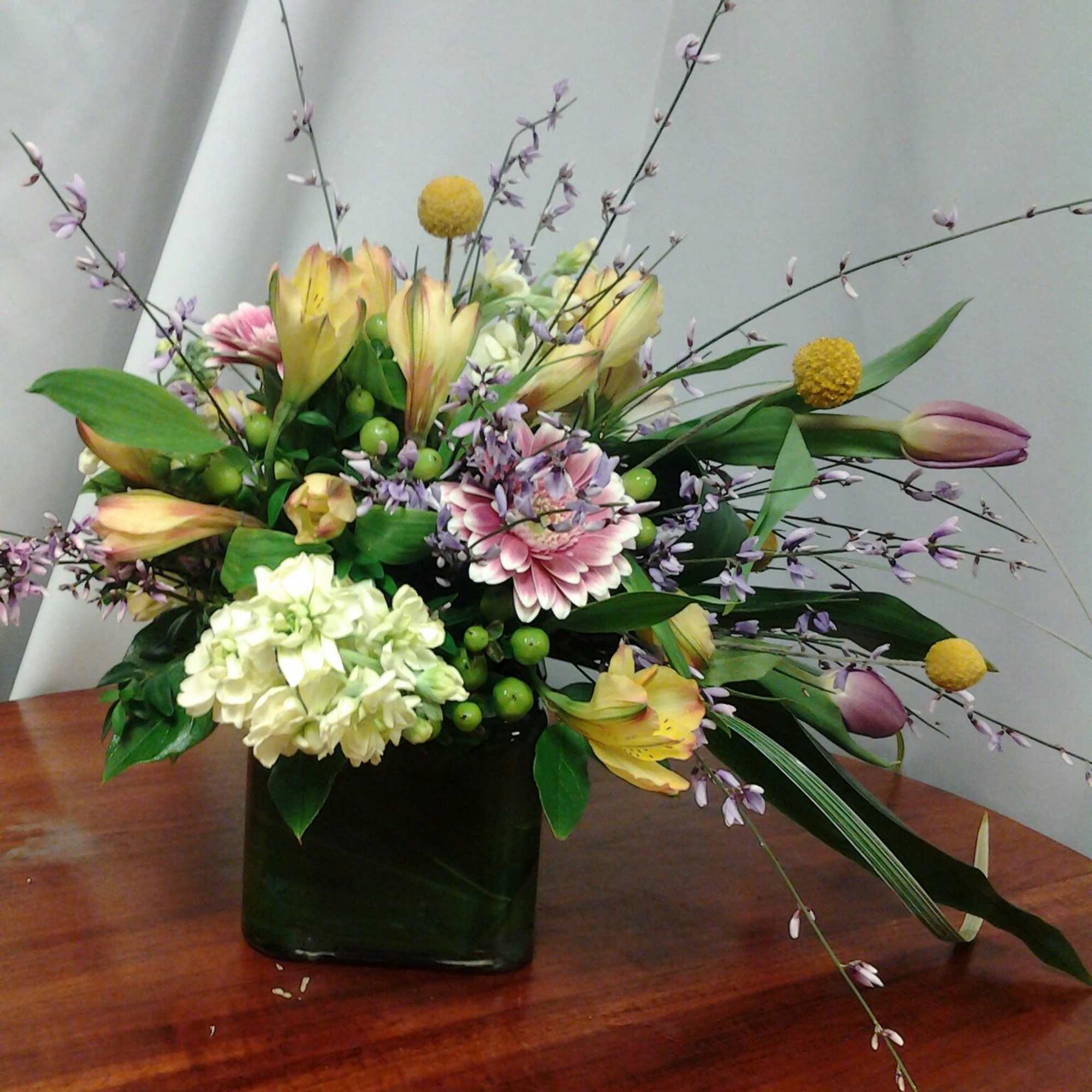 With a mixture of roses, asters, other flowers along with some bling