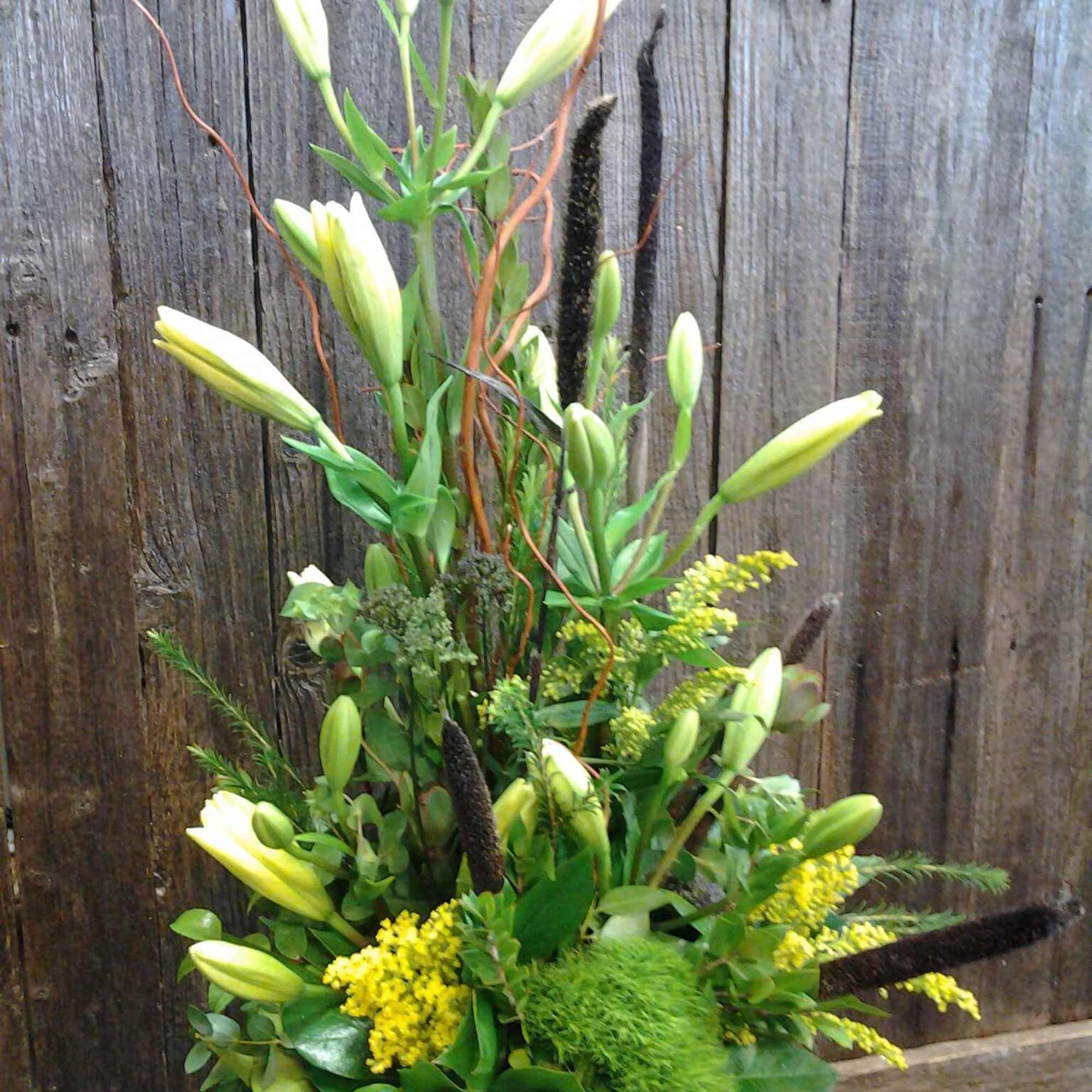 With a mixture of roses, asters, other flowers along with some bling