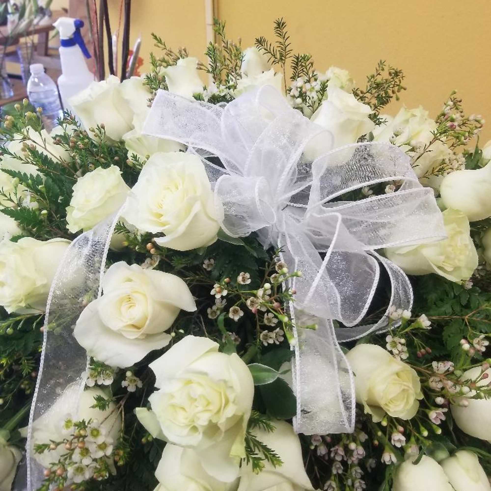 36 WHITE ROSES with Filler and WHITE BOW.  Casket measures about