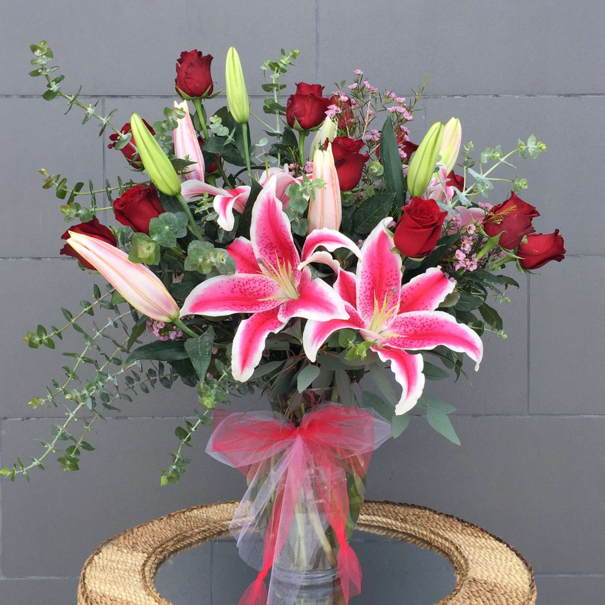 Stargazer lilies, Ecuadorian roses with nice accents in a tall glass vase. Stargazer lilies, Ecuadorian roses with nice accents in a tall glass vase.