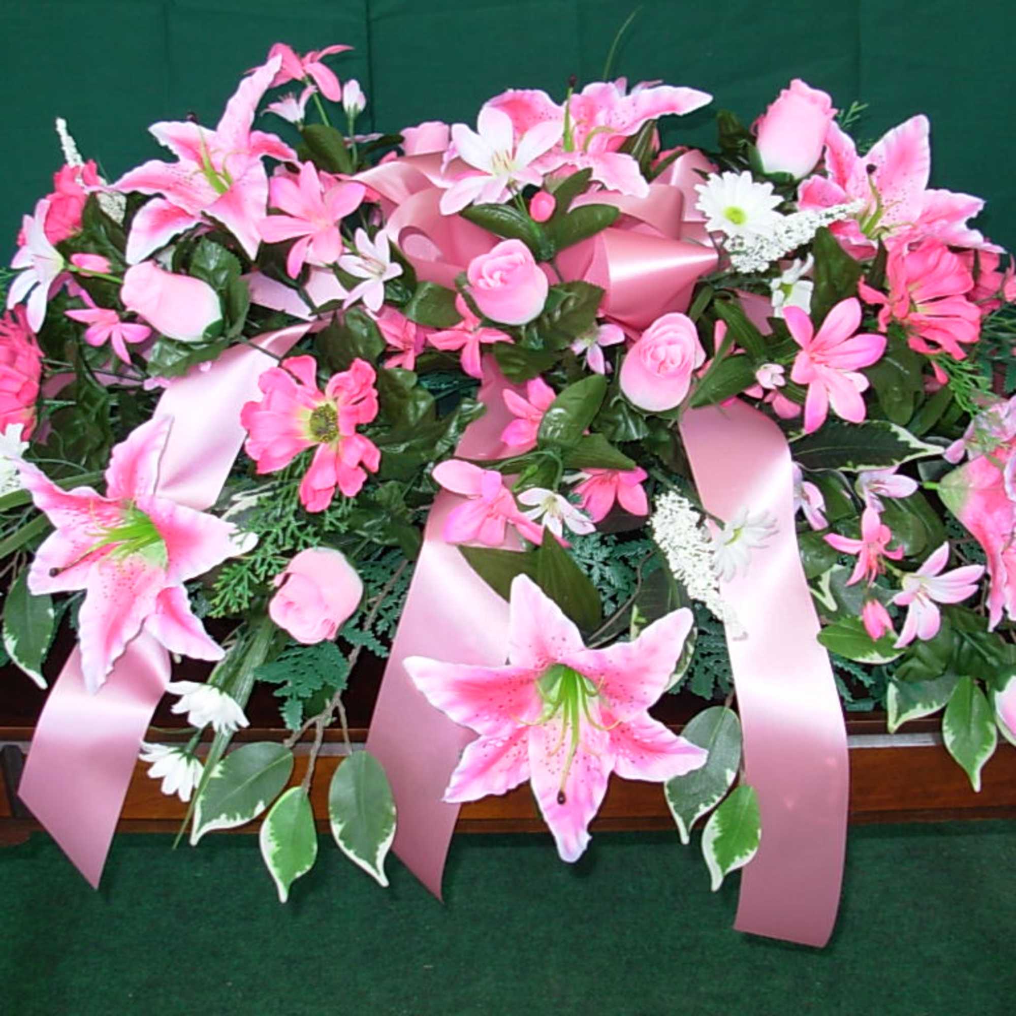 Our SILK - PERMANENT LILLY CASKET SPRAY  is made of pink