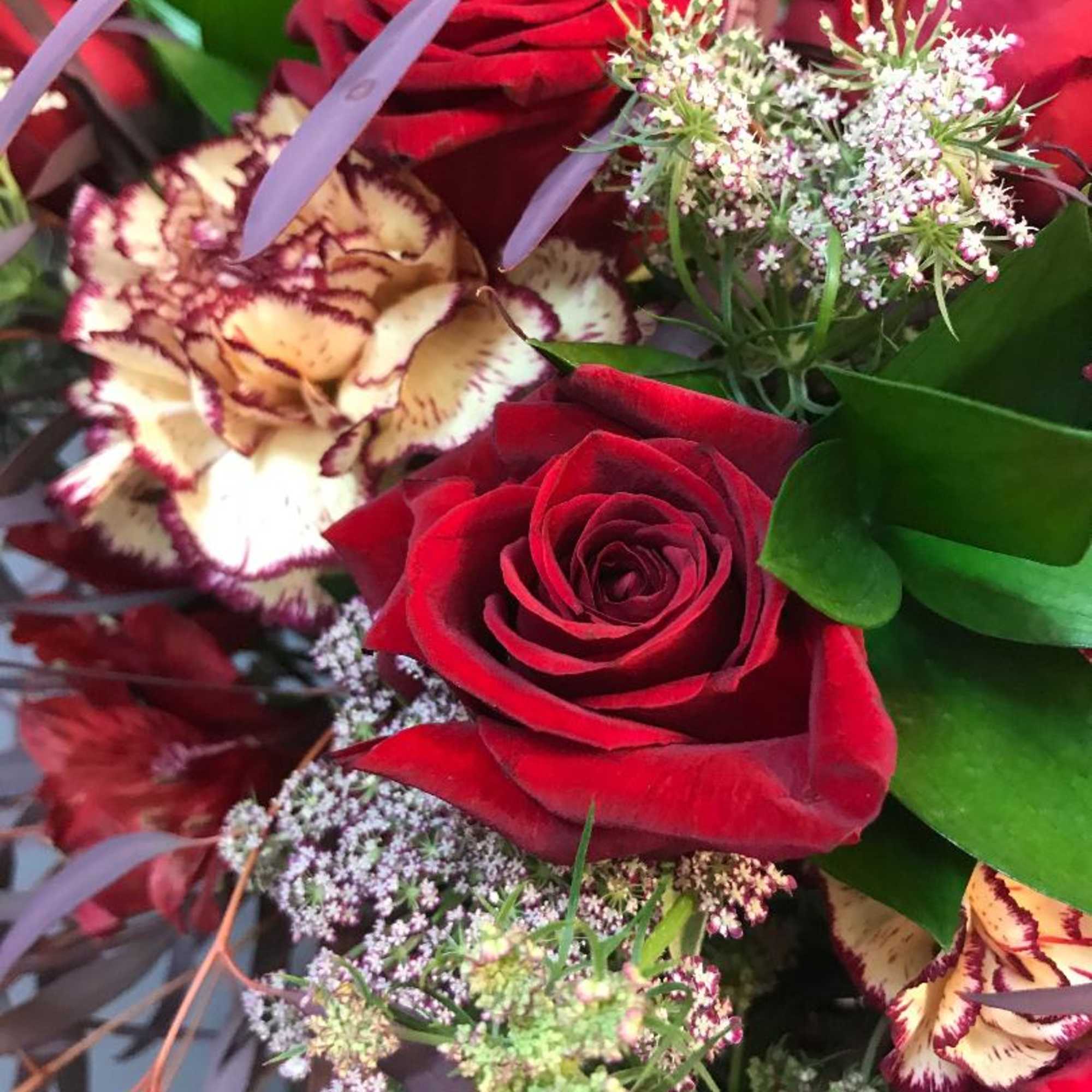 loose garden design in modern angular vase assorted blooms of roses, carnations