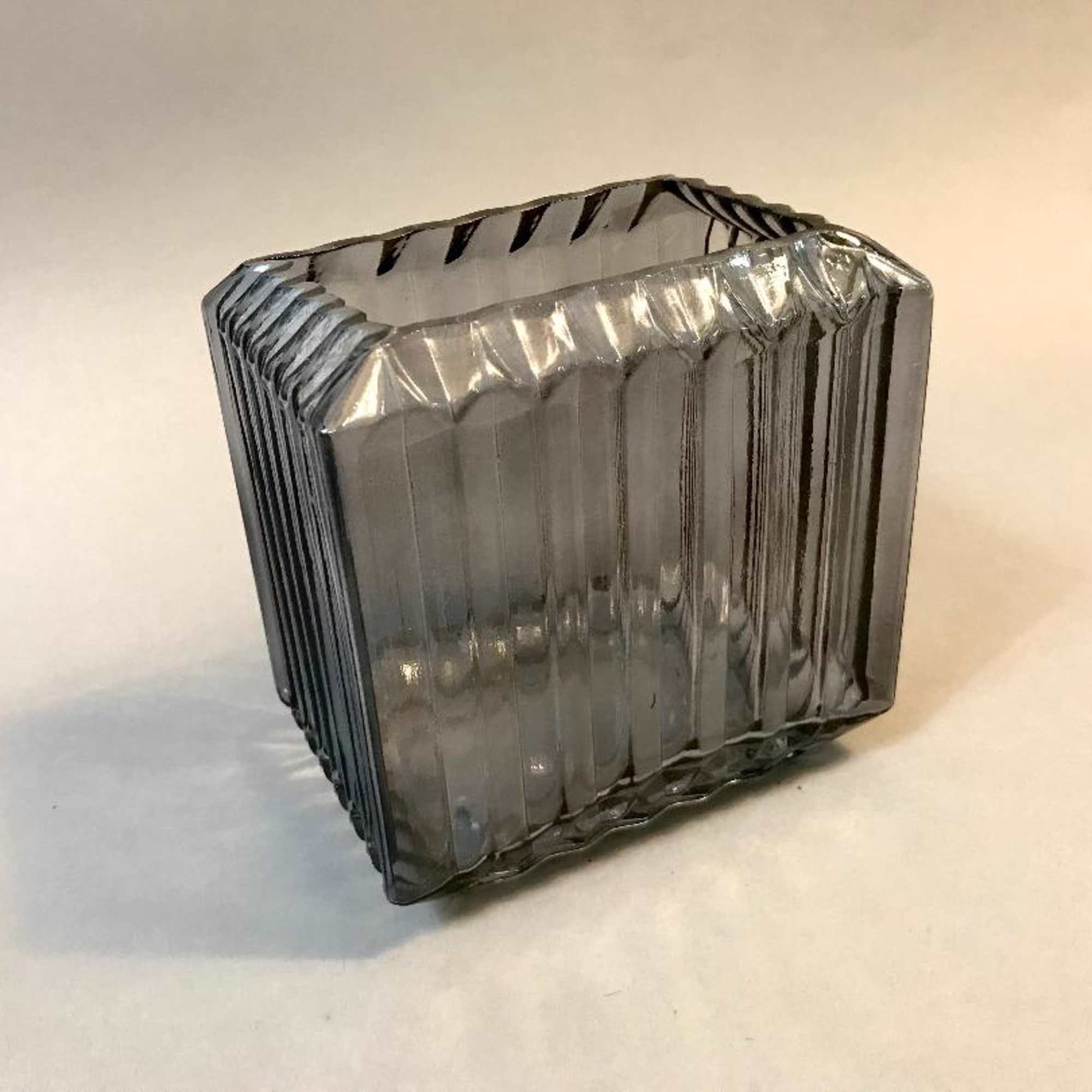 Smoke glass vase with abundant blooms of reds and burgundy roses