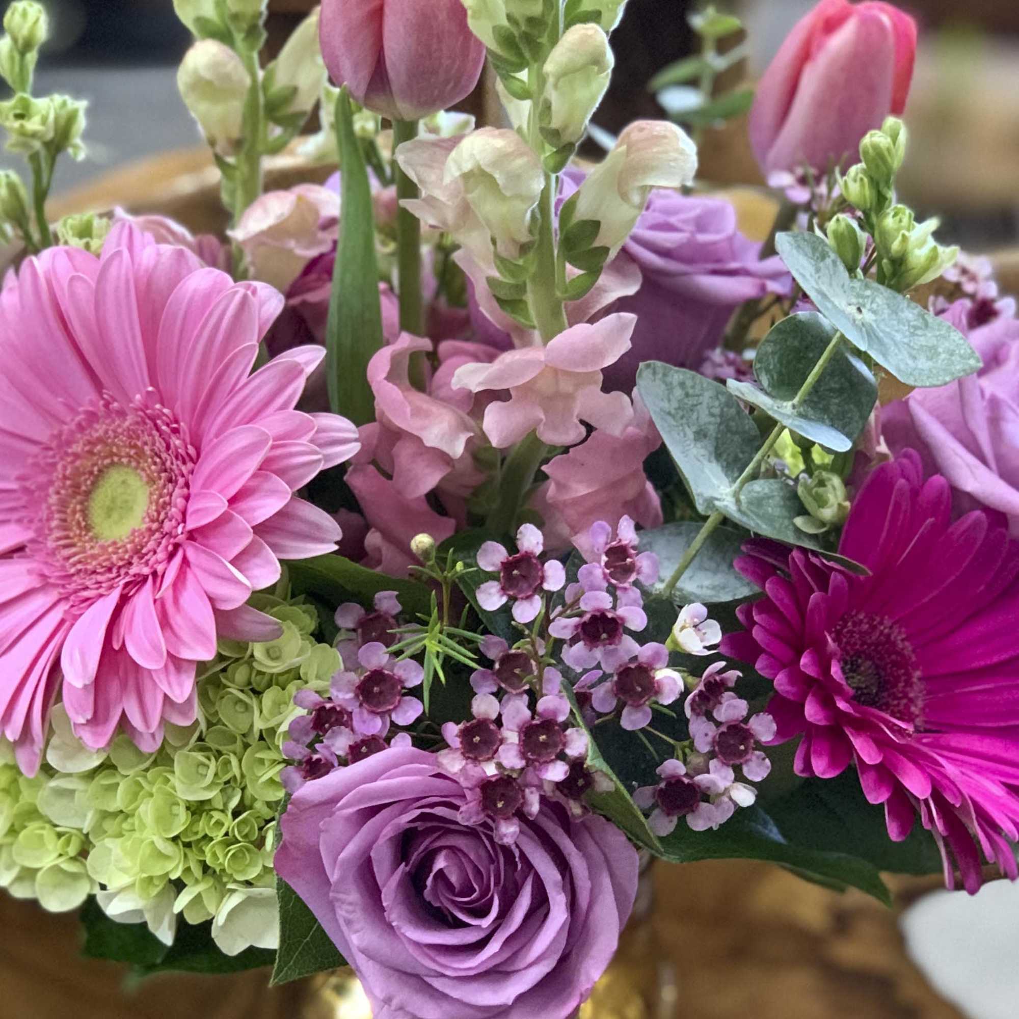A bright colorful mix off Gerber daisies roses, hydrangeas, baby euc, tulips