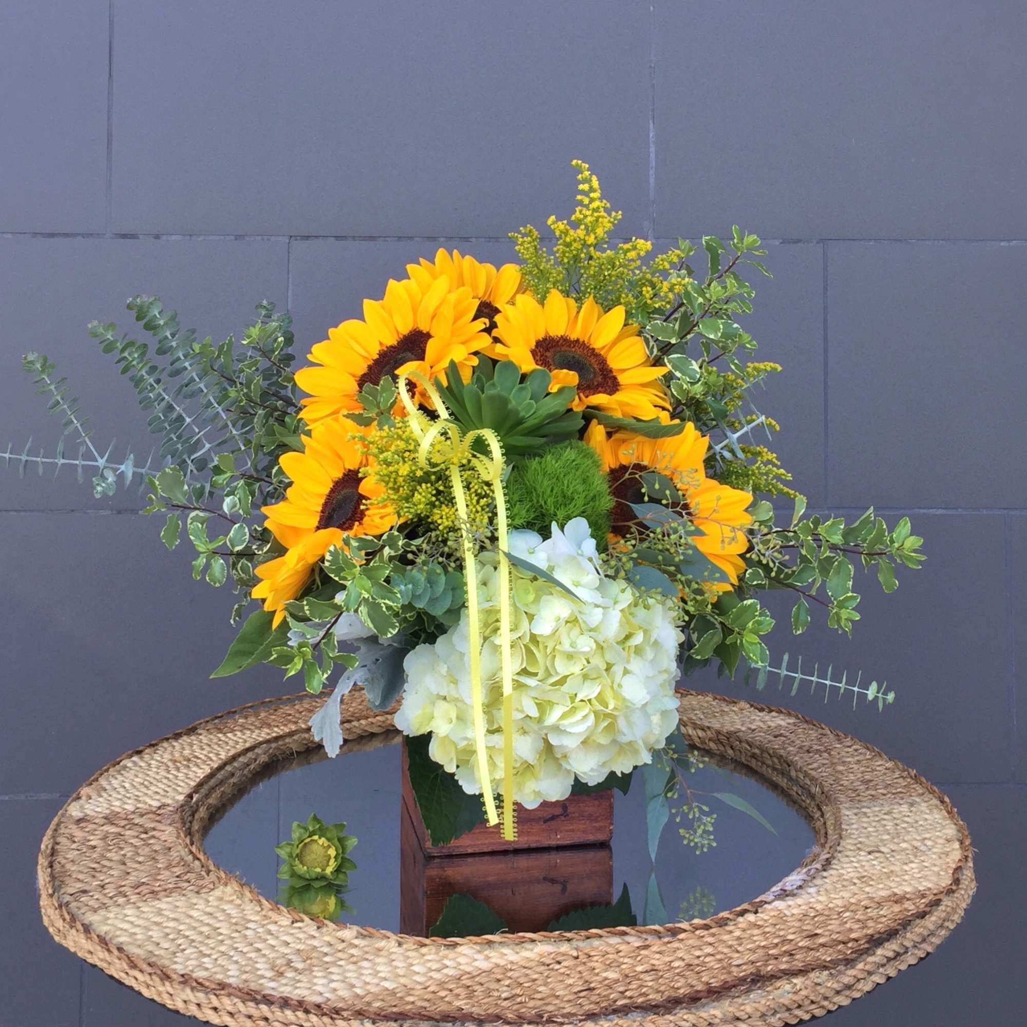 Sunshine design including sunflowers, succulent and accents in a wood box.
STANDARD: FIRST