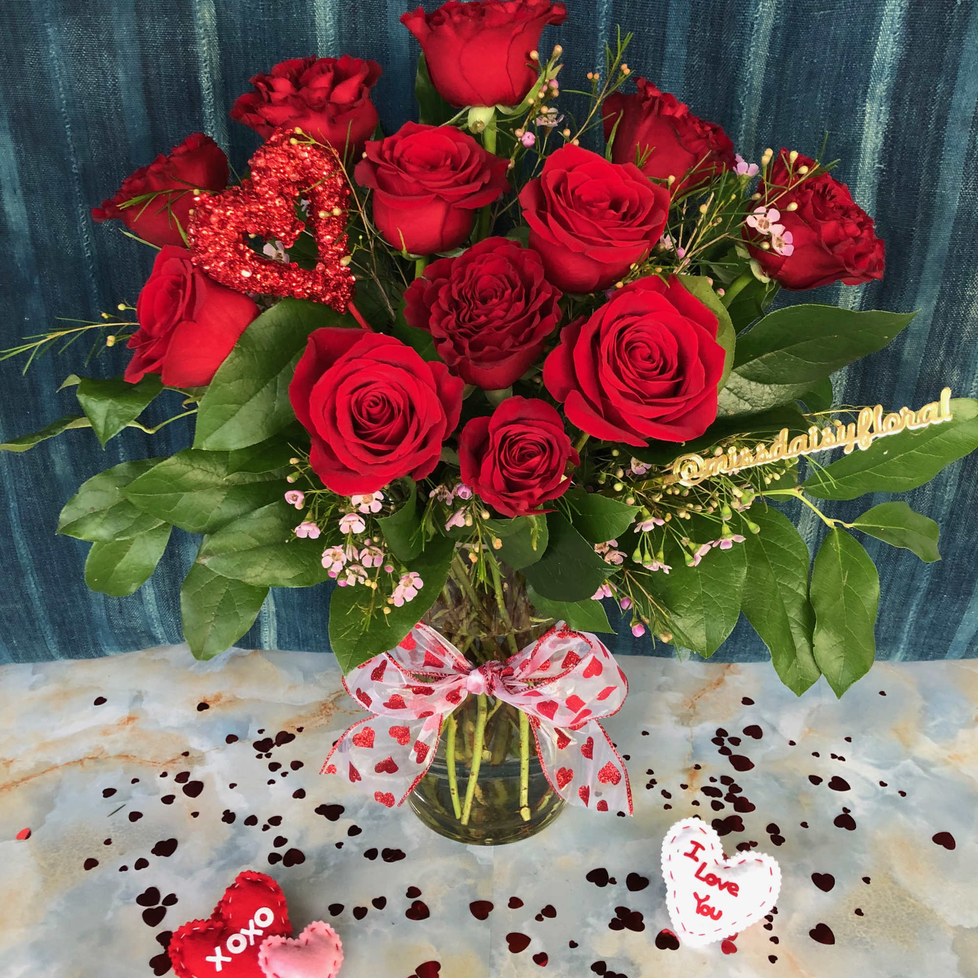 One dozen long stem red roses styled in a tall vase. This
