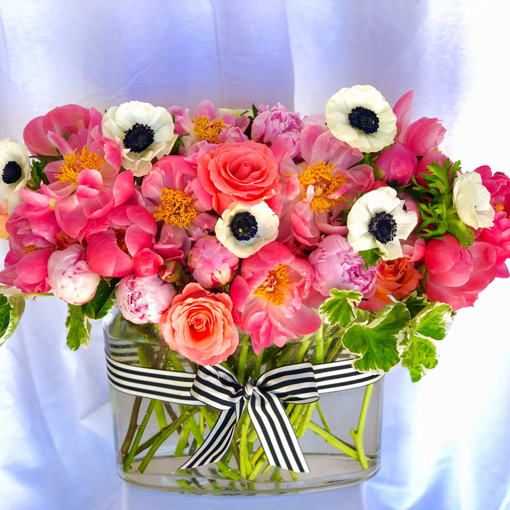 A stunning, lush arrangement that is overflowing with peonies, garden roses, anemones