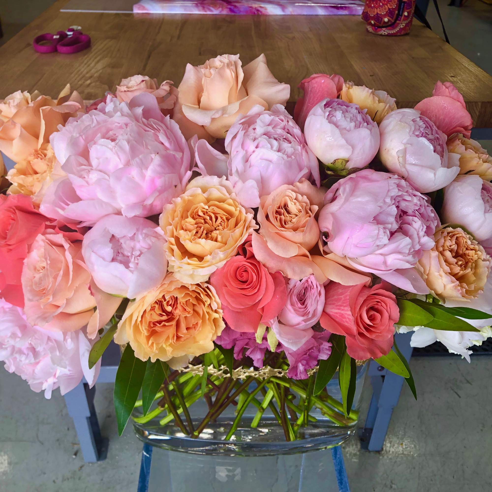 A stunning, lush arrangement that is overflowing with peonies, garden roses, anemones