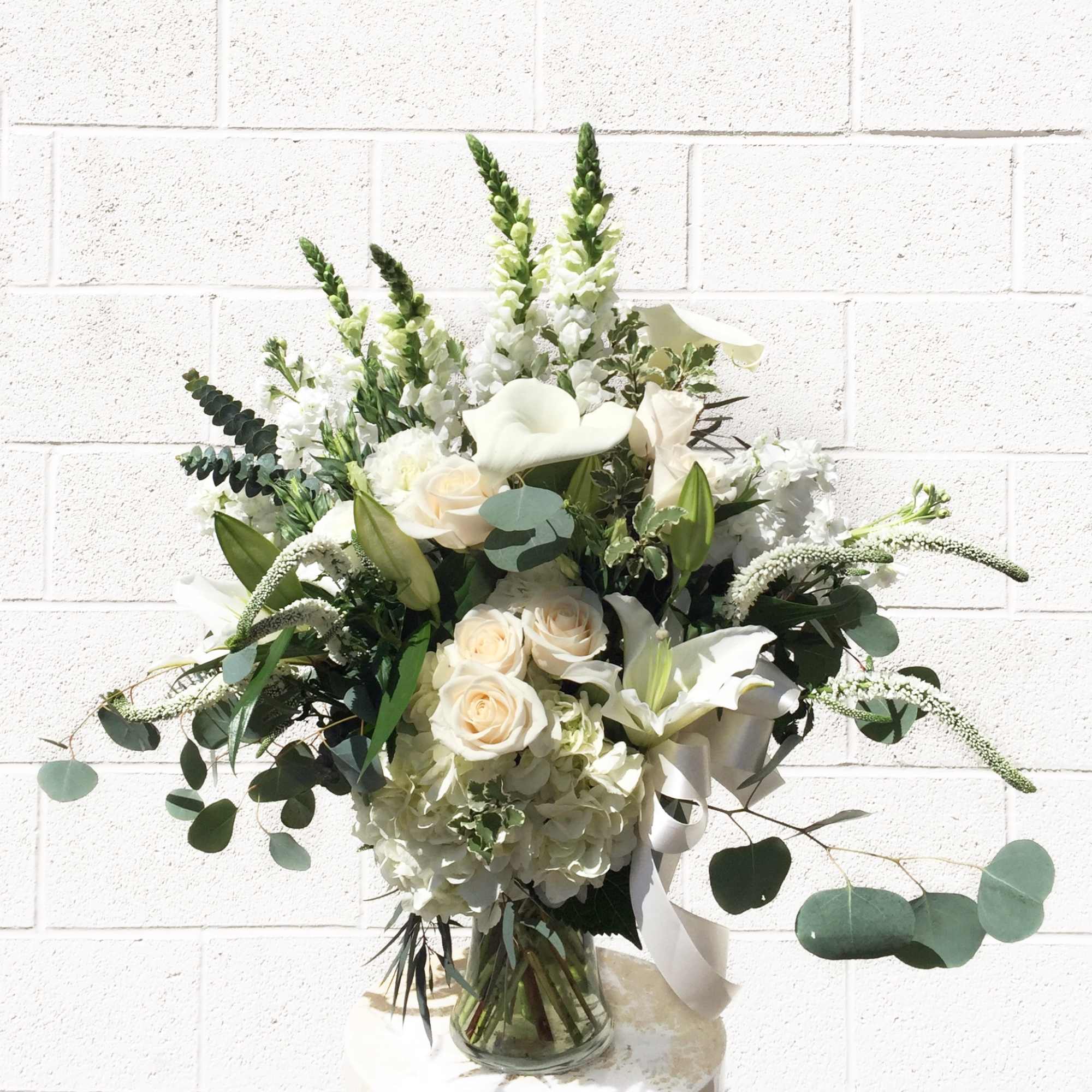 A classic all white design with all premium flowers: lilly, hydrangea, rose