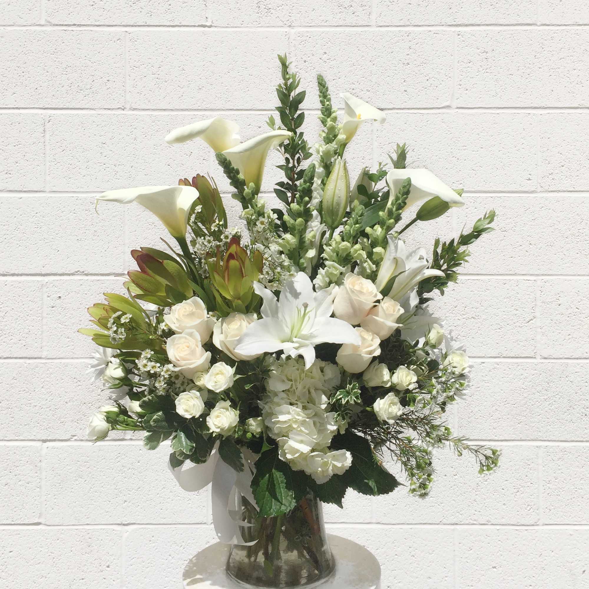 A classic all white design with all premium flowers: lilly, hydrangea, rose