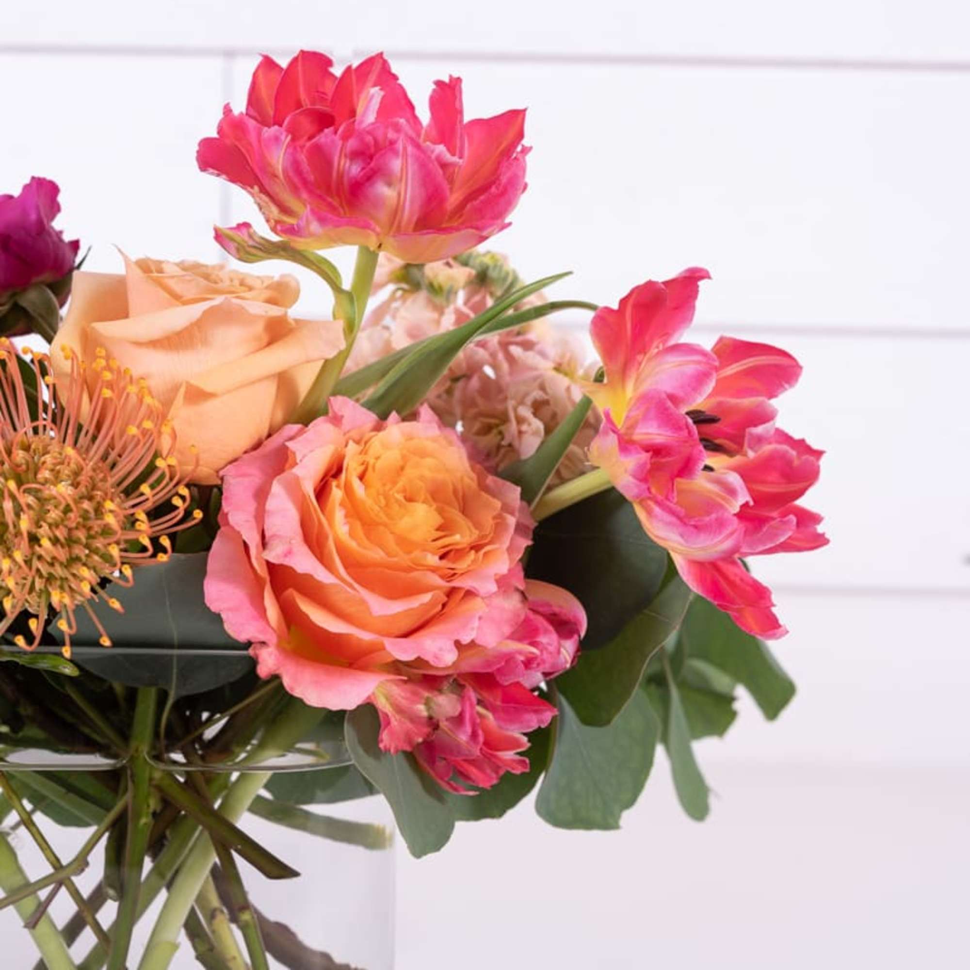 Tropical inspired vessel of flowers.  Filled with amazing blooms in a