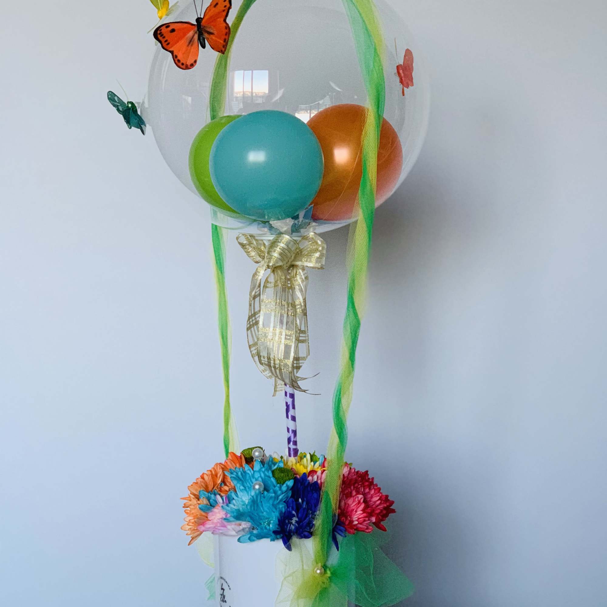 Tall mixed floral arrangement and a bubble balloon, colors may be requested