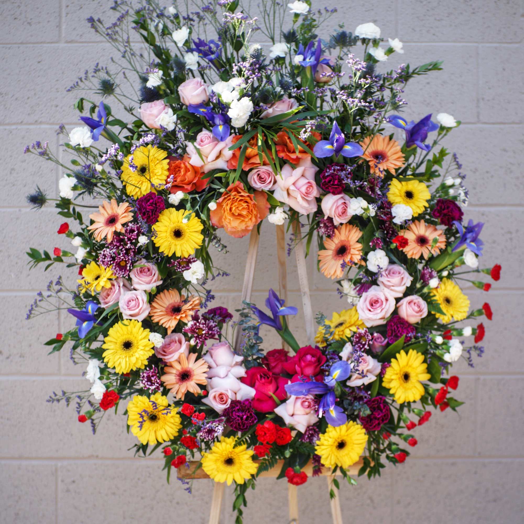 Beautiful wreath including rose, iris, gerbera, carnation... and accents.