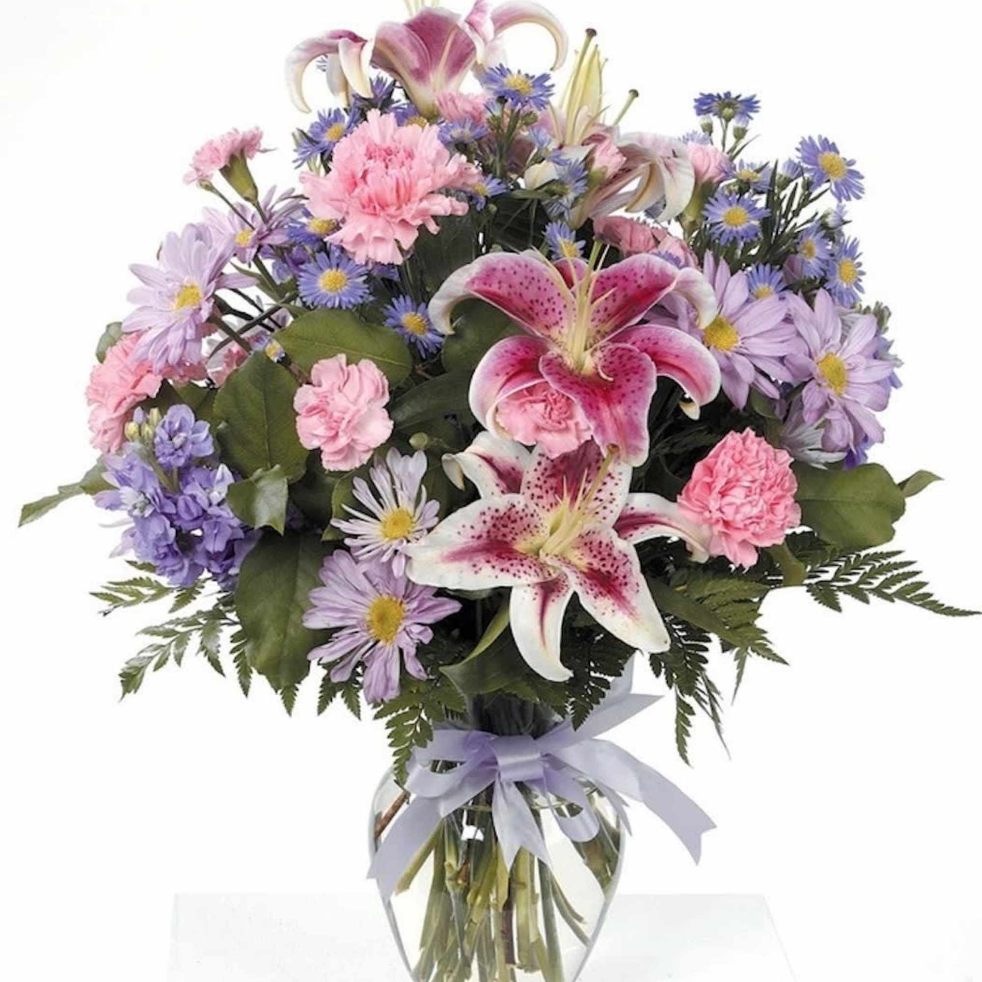Beautiful stargazer lilies in a glass vase with pink carnations, lavender daisies