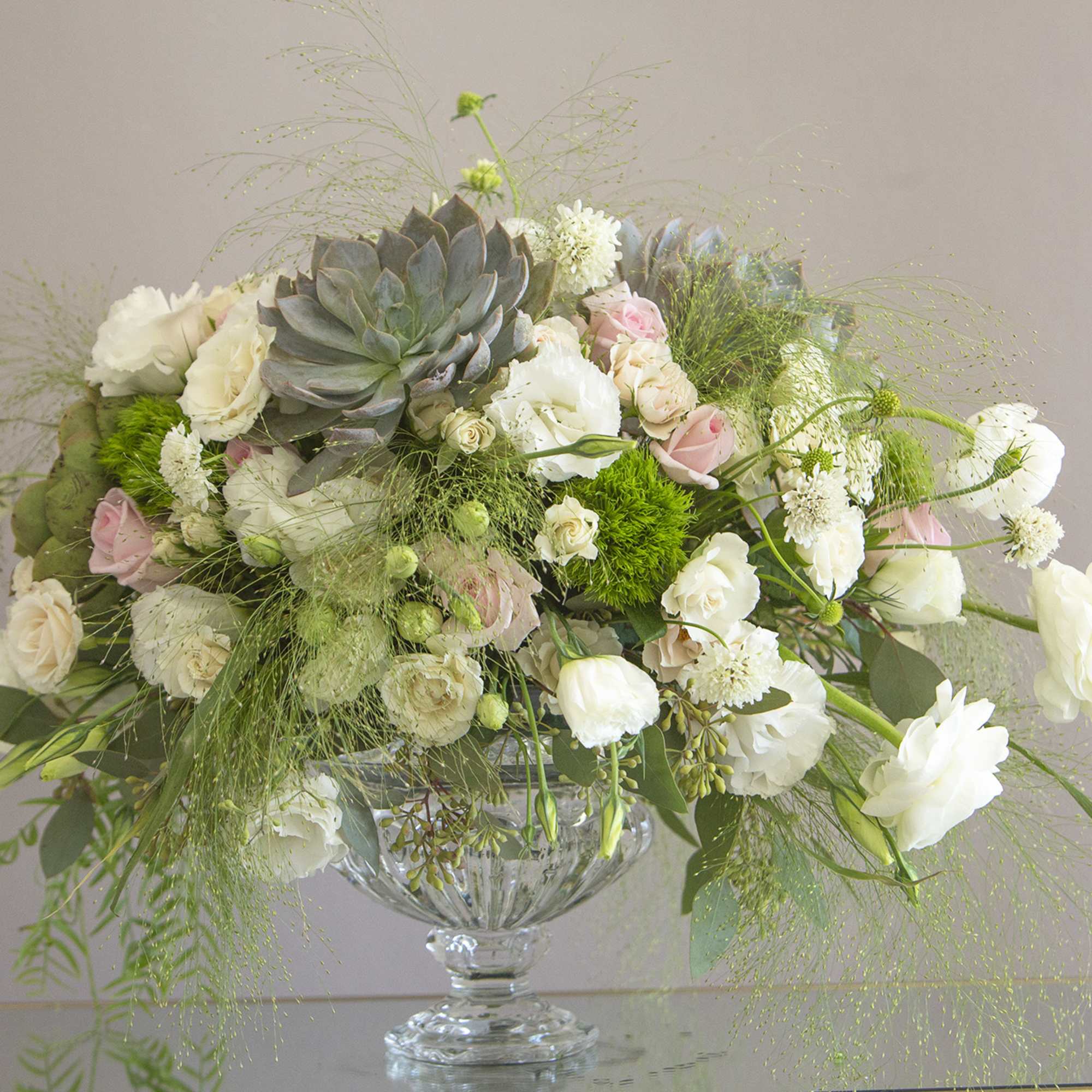 A stunning creation of exotic greens and white blooms accompanied by succulent A stunning creation of exotic greens and white blooms accompanied by succulent