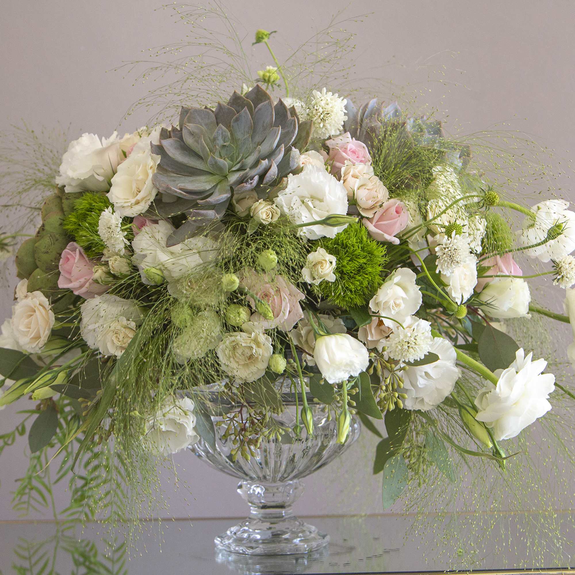A stunning creation of exotic greens and white blooms accompanied by succulent A stunning creation of exotic greens and white blooms accompanied by succulent