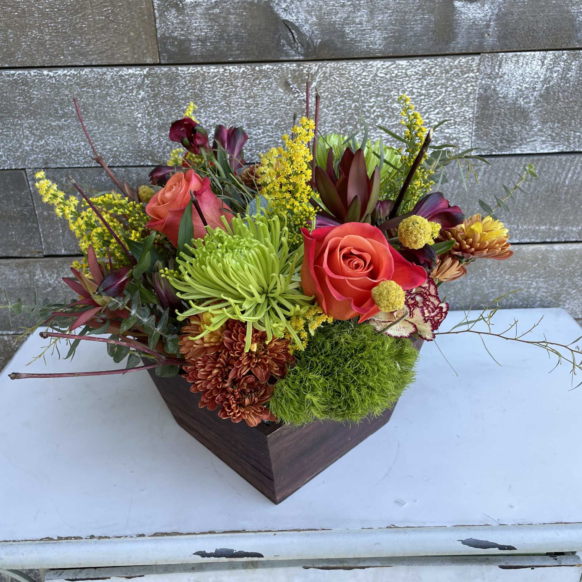 Elegant arrangement of fall bliss in an oak tapered wooden box.  Elegant arrangement of fall bliss in an oak tapered wooden box.