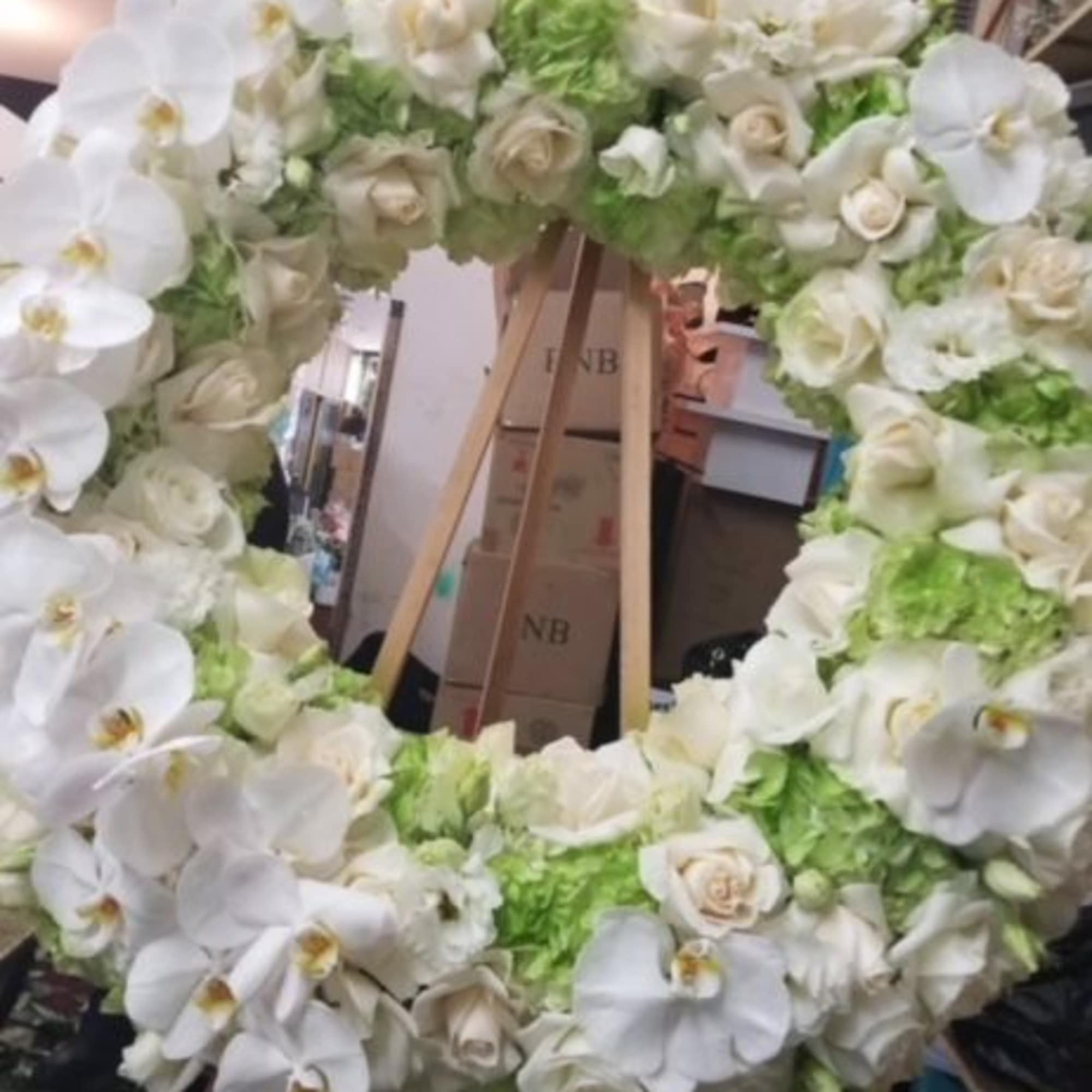 A heart shaped standing spray filled with roses, hydrangeas, phale orchids, and