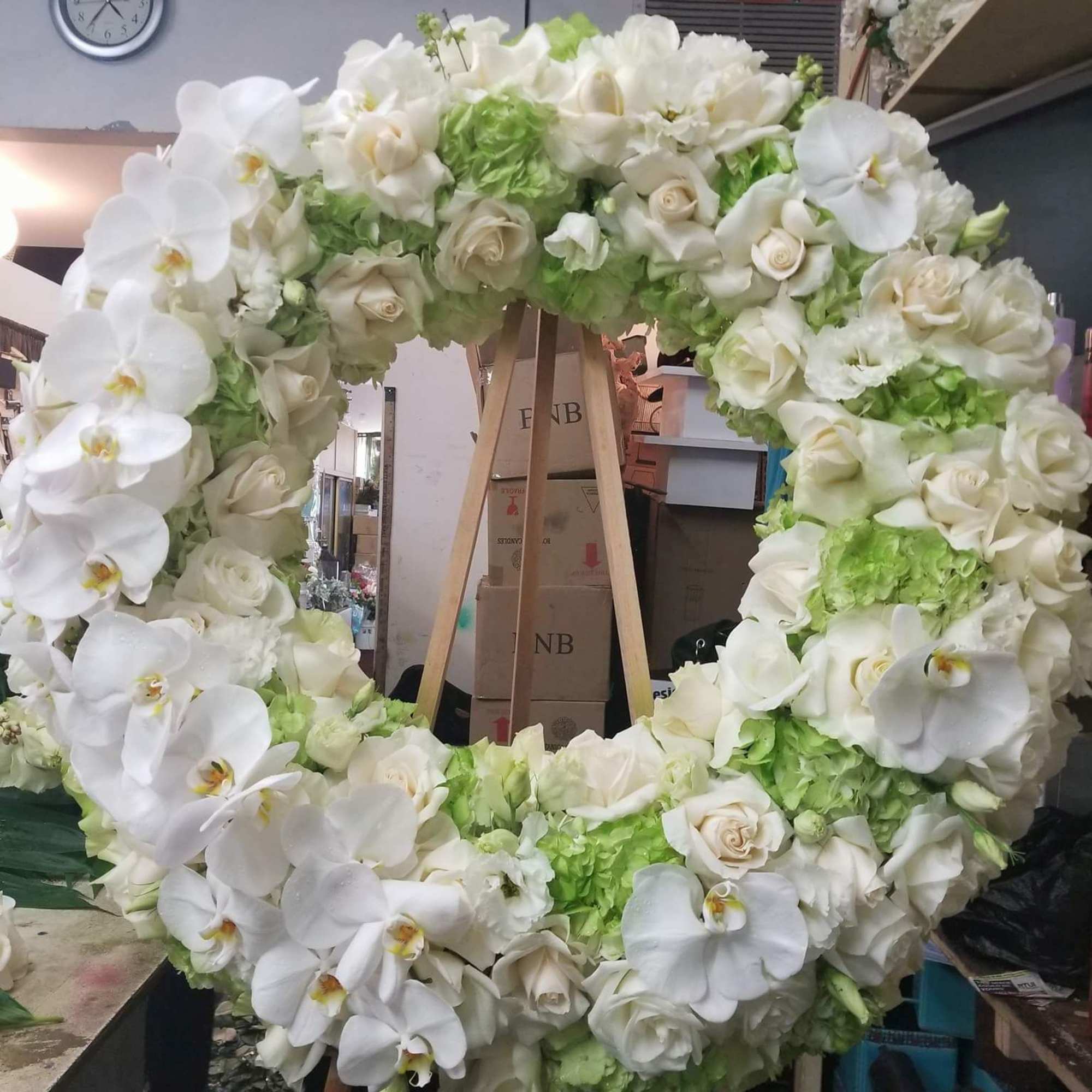 A heart shaped standing spray filled with roses, hydrangeas, phale orchids, and