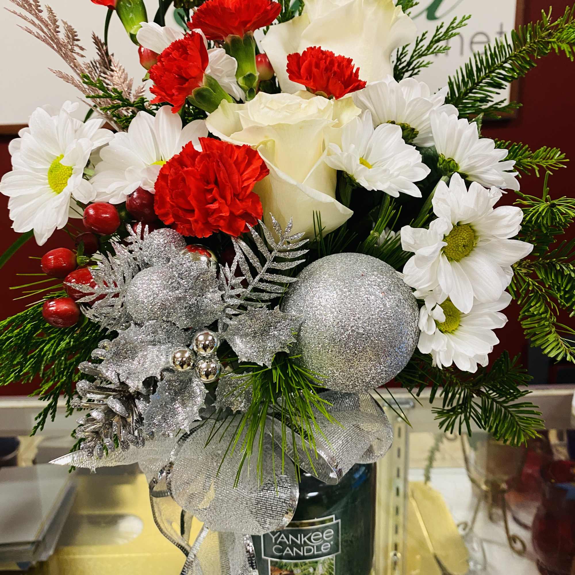 Beautiful arrangement on top of a Yankee Candle.