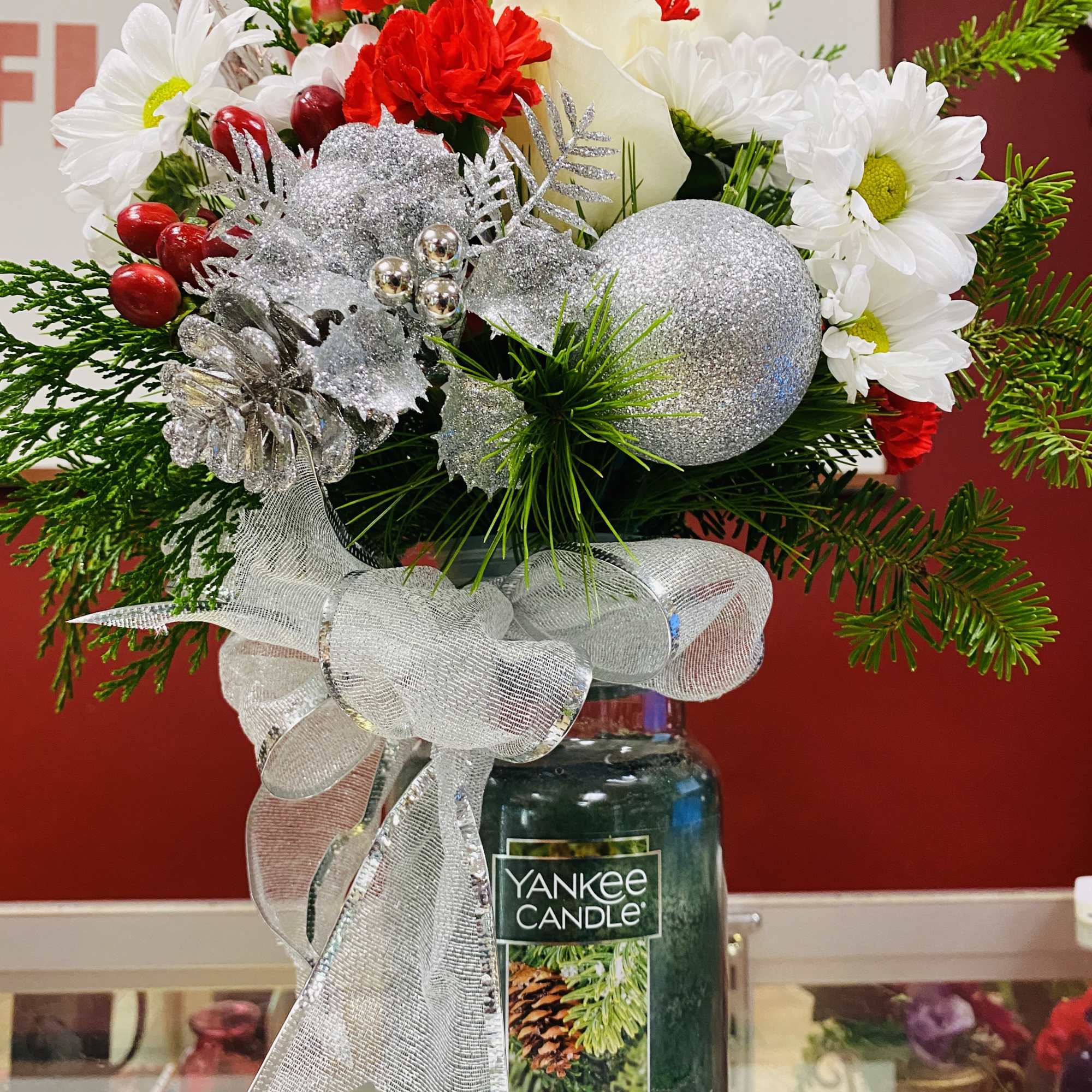 Beautiful arrangement on top of a Yankee Candle.