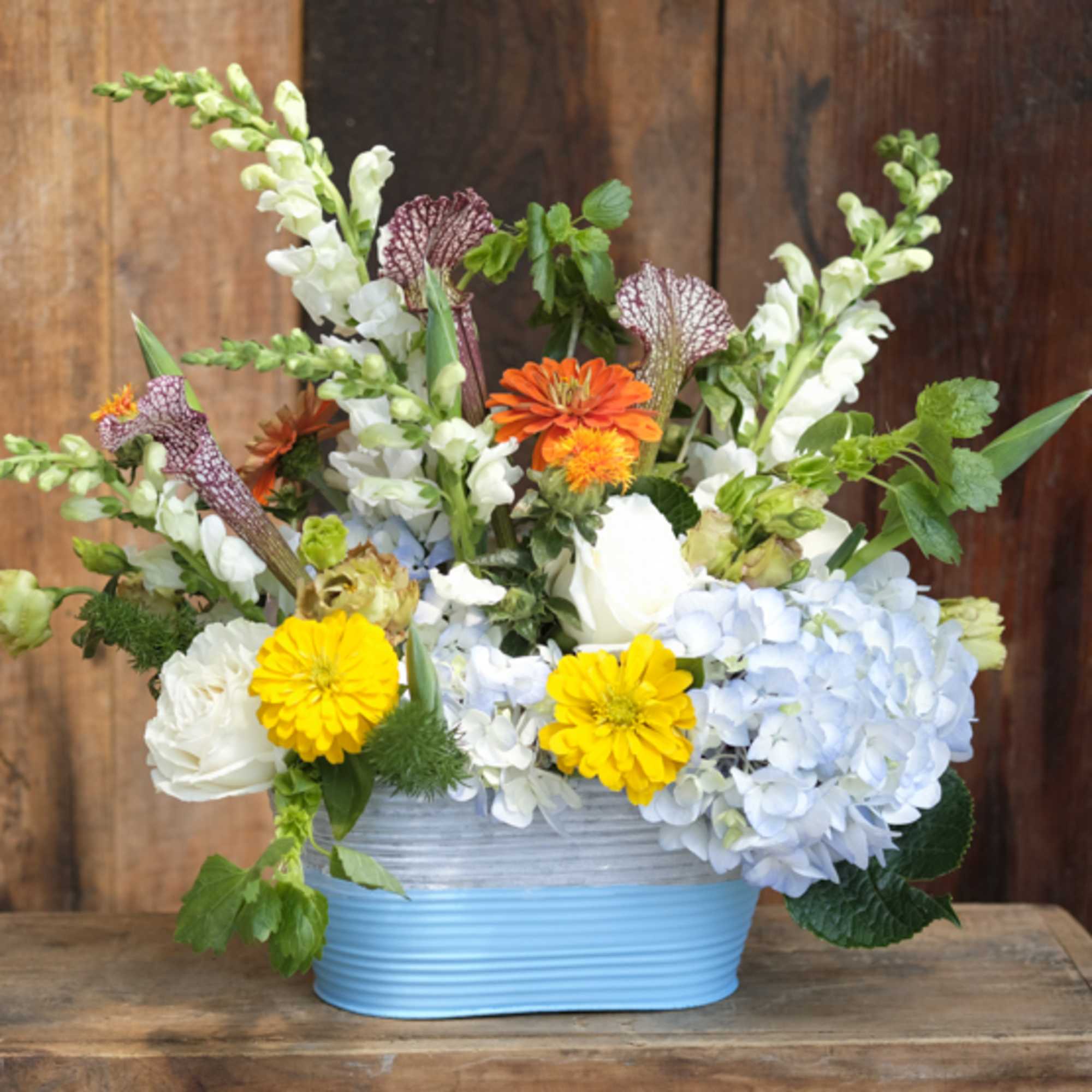 Our artisan handmade arrangement&#039;s overall theme is monochromatic with blues and whites.