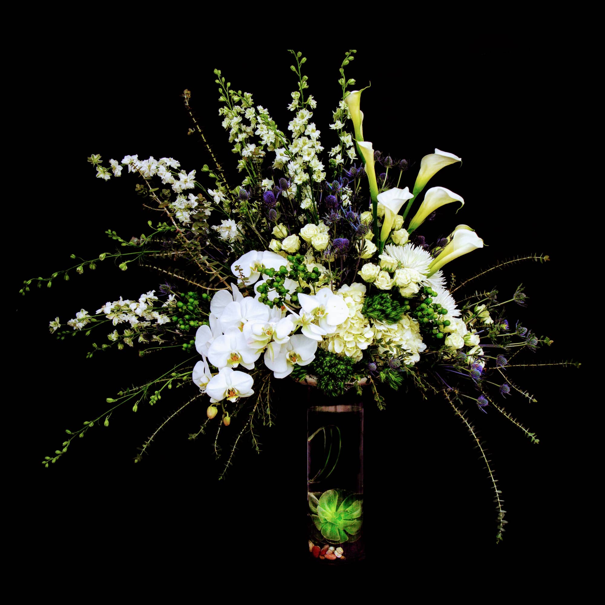 Elegant white including all premium flowers and accents in a tall glass
