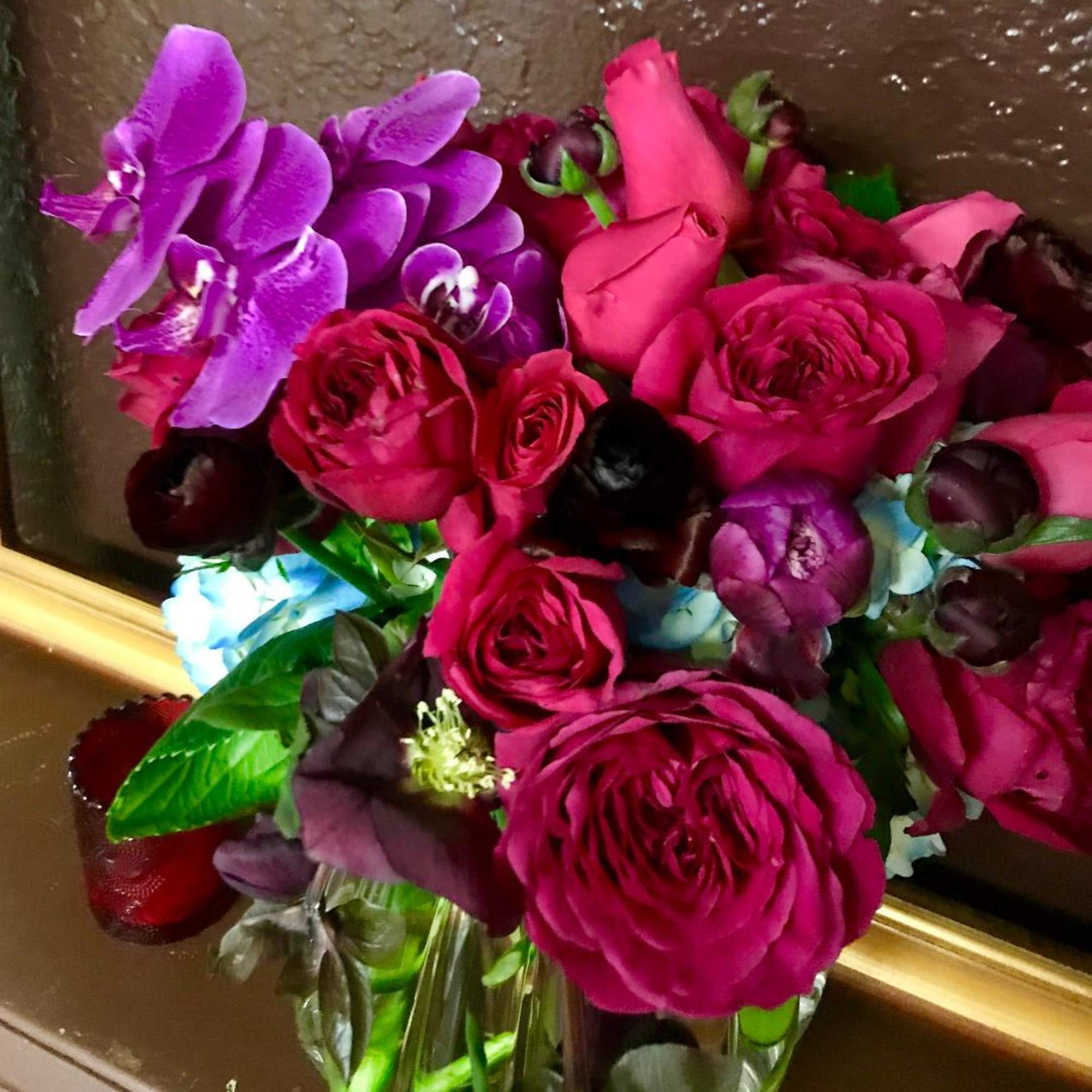 Hot pink roses and purple orchids and same colors of seasonal flowers.