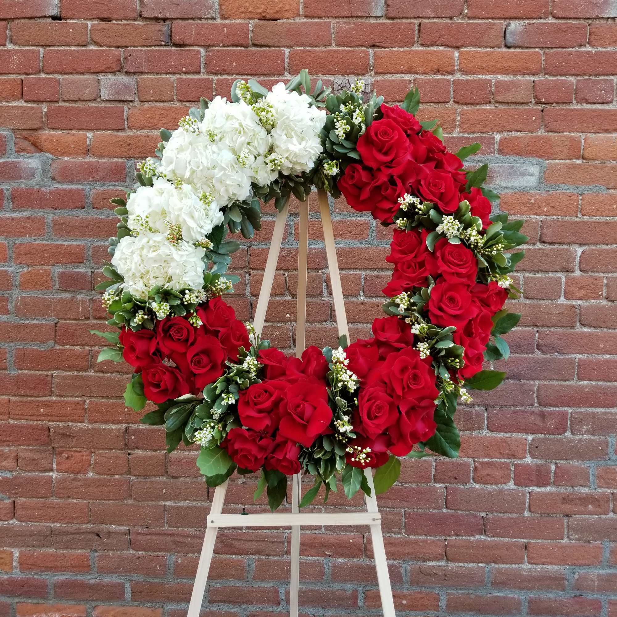 Composed of roses, hydrangeas, fillers, variety of green. Stand included.