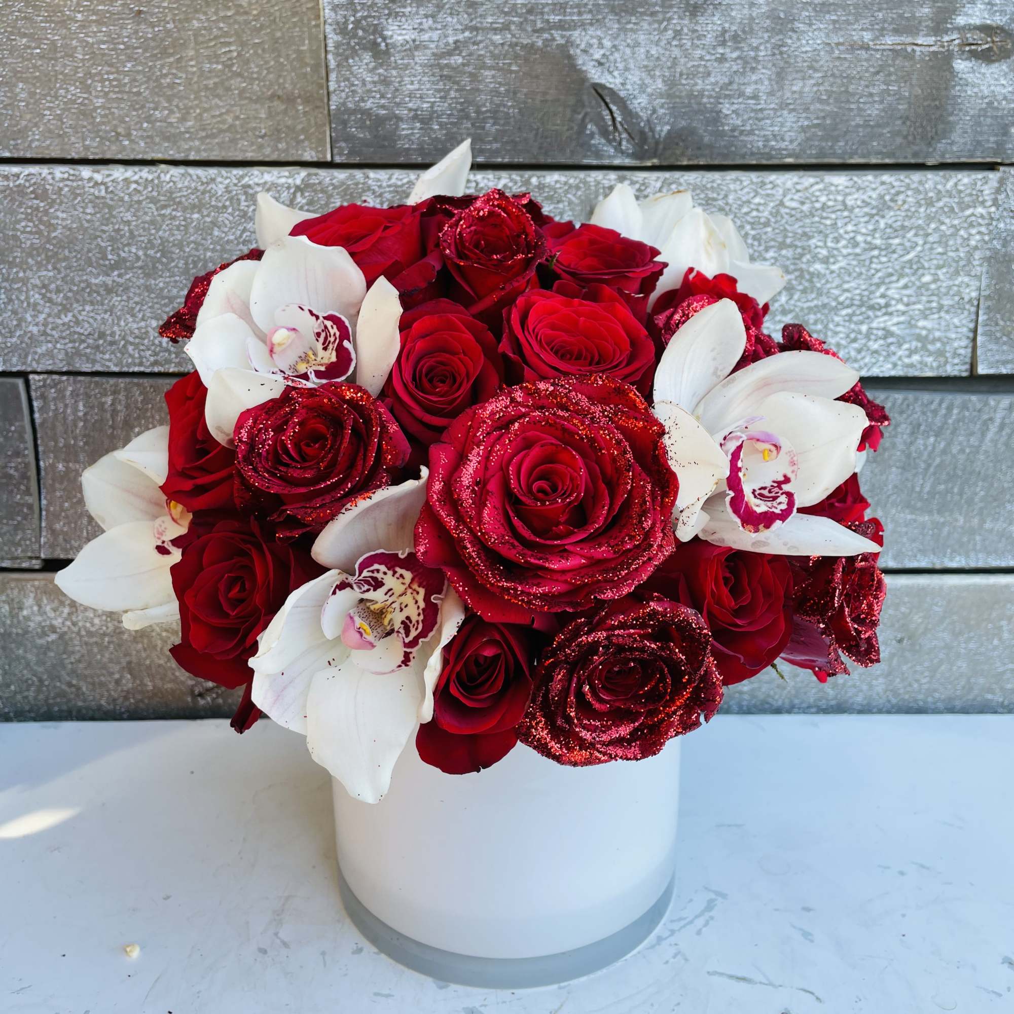 Some gorgeous red glittered roses in a pave with white cymbidium orchids Some gorgeous red glittered roses in a pave with white cymbidium orchids