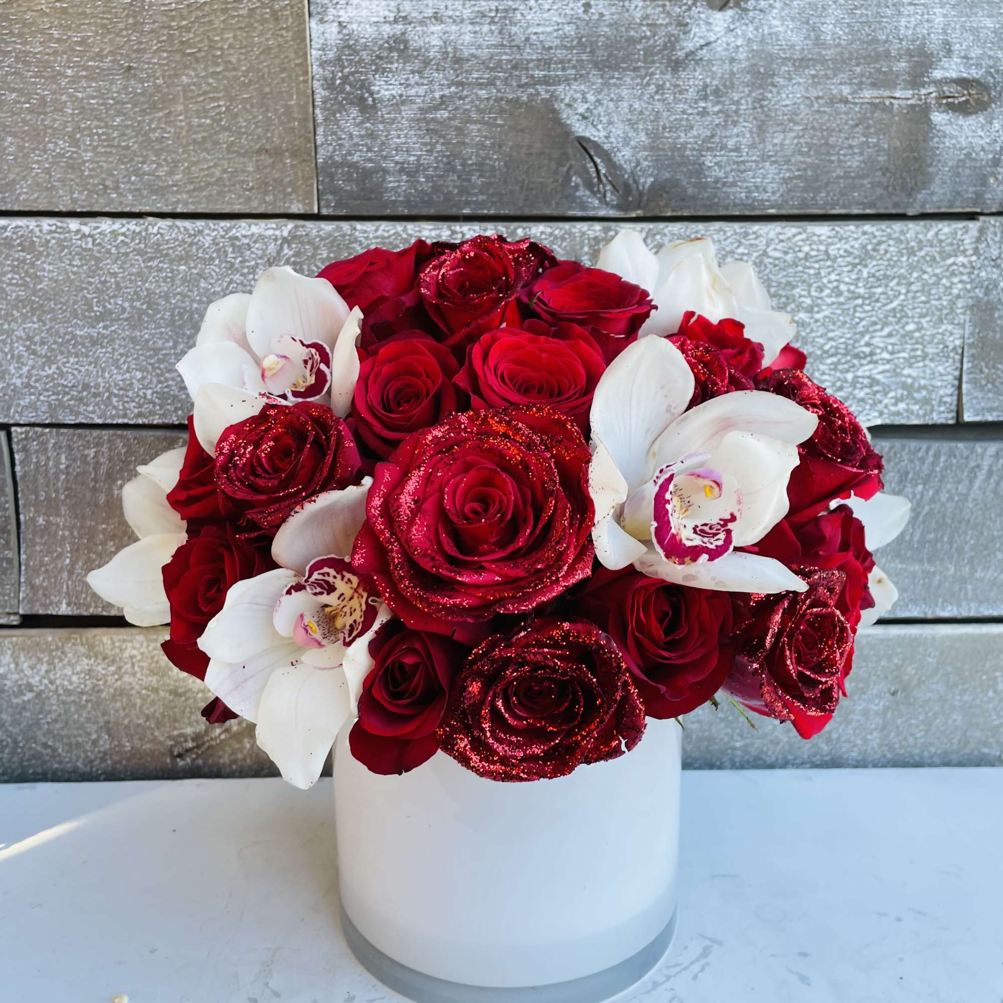 Some gorgeous red glittered roses in a pave with white cymbidium orchids Some gorgeous red glittered roses in a pave with white cymbidium orchids
