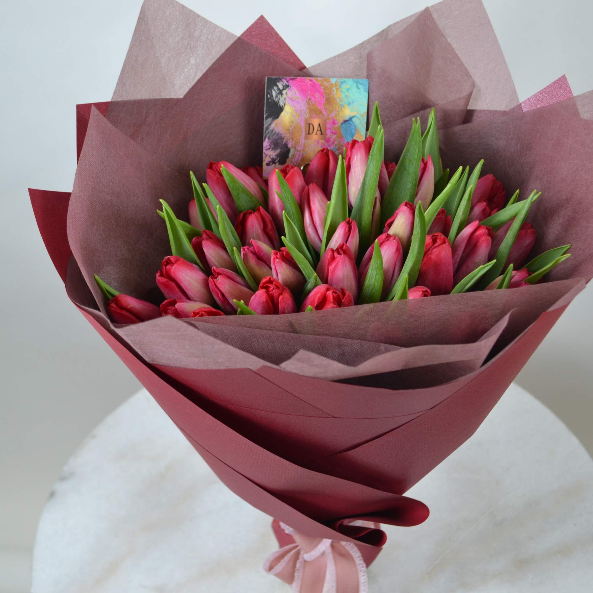 Hand tie bouquet of magnificent tulips in bright red tone.