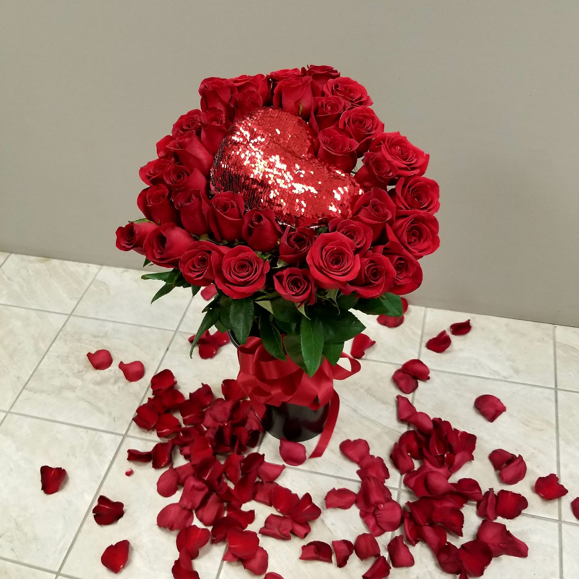 Long stem roses in a heart shaped bouquet tied with a satin