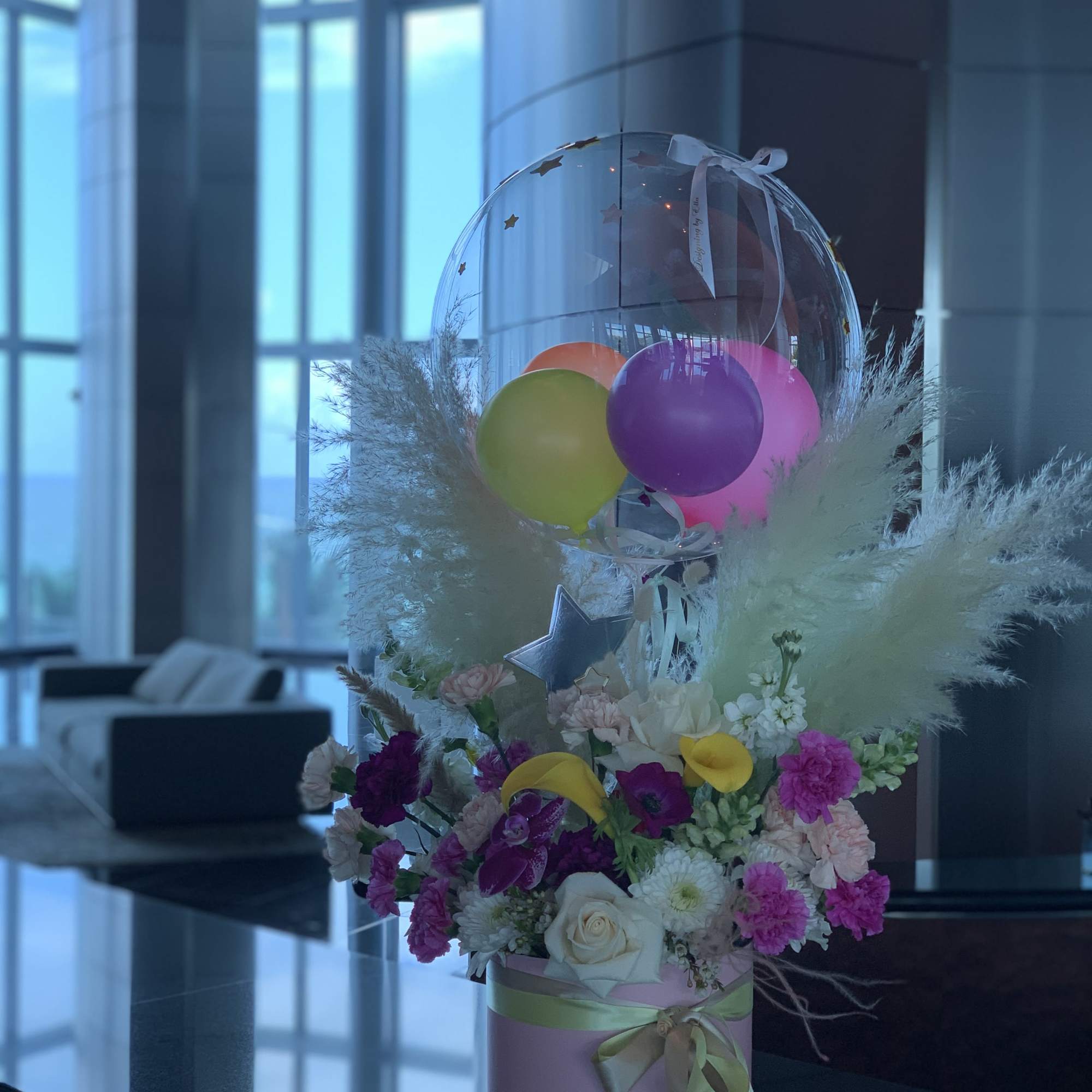 Mixed flower in a hat box crowned by the bubble balloon, decorated