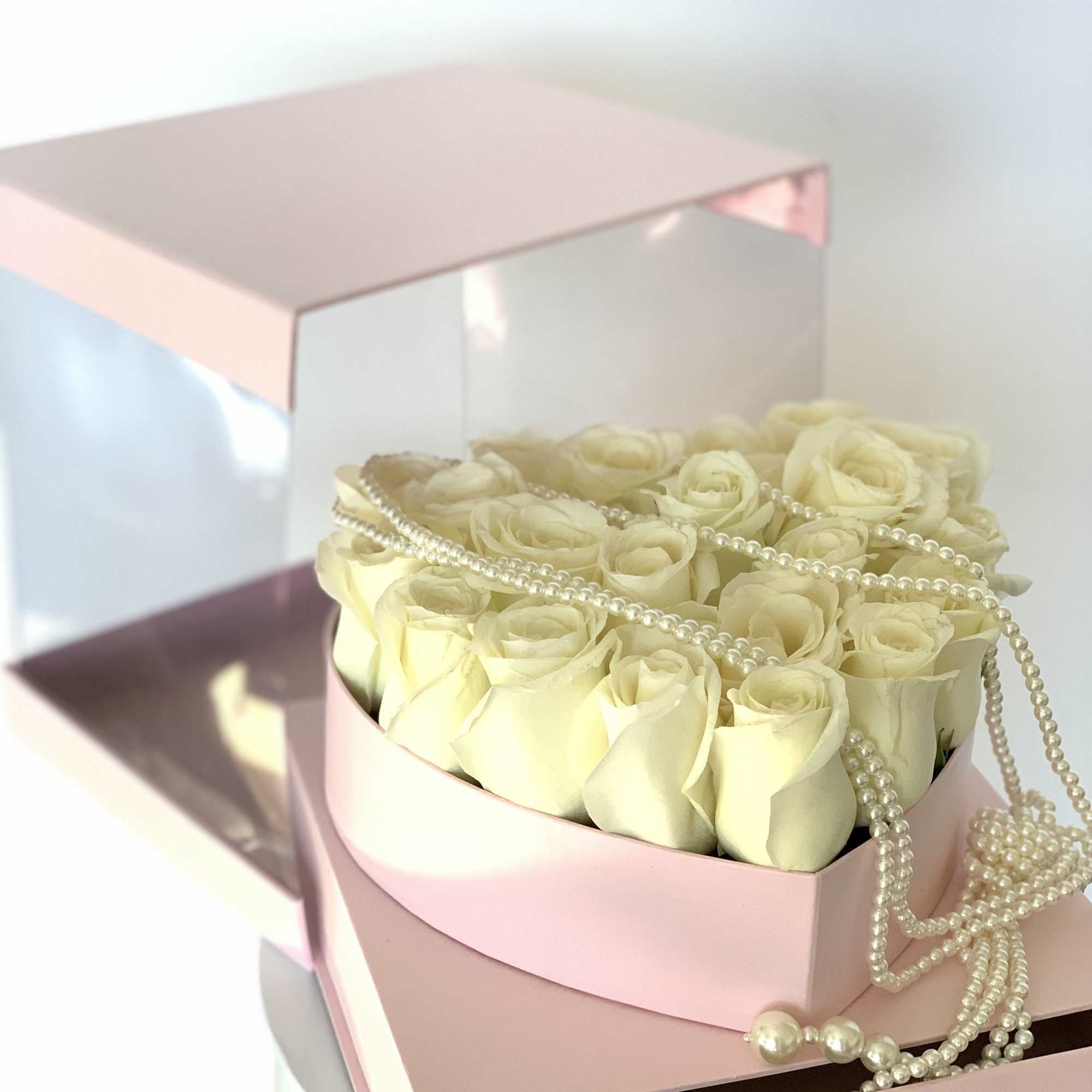 Fresh rose heart in a floral box in addition of a pearl