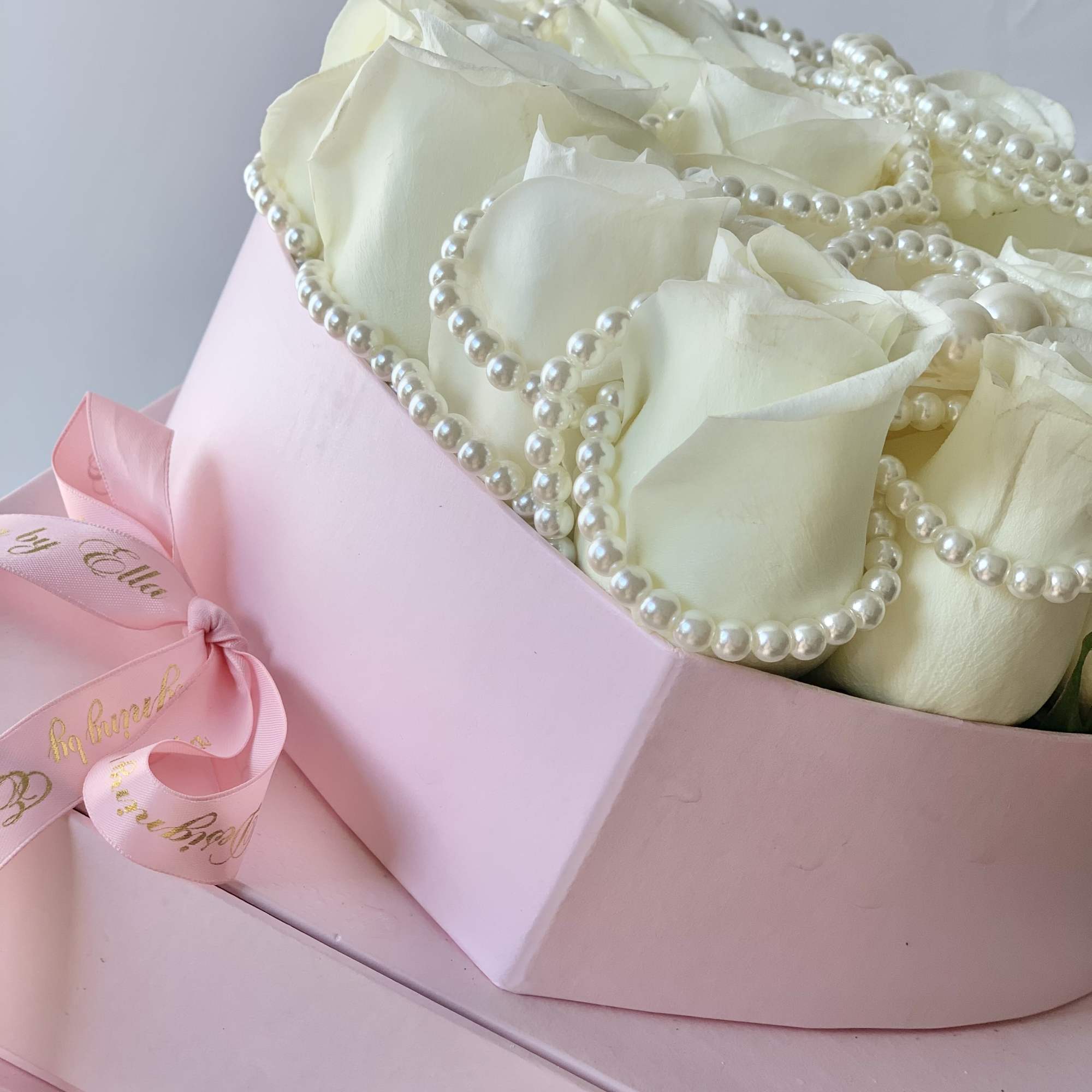 Fresh rose heart in a floral box in addition of a pearl