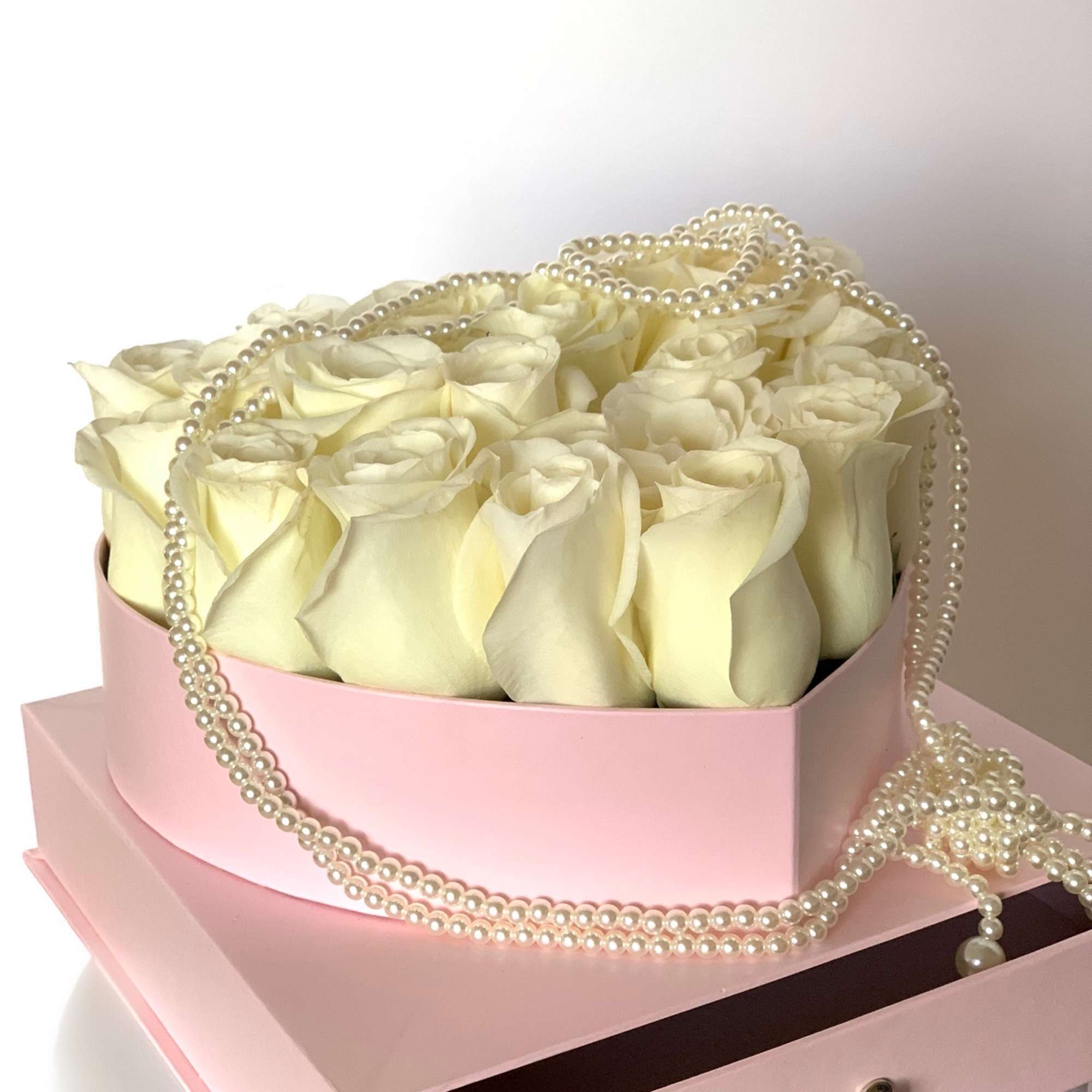 Fresh rose heart in a floral box in addition of a pearl