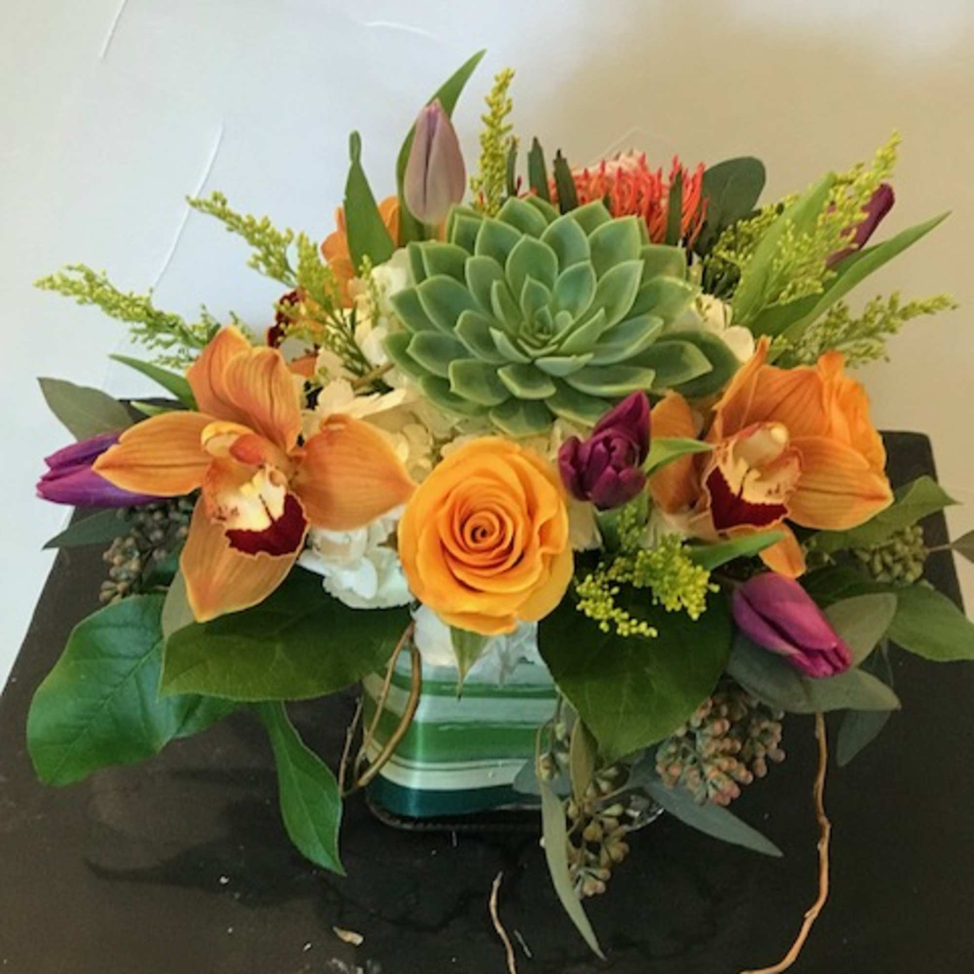 hydrangea, succulent, pin cushion protea, cymbidium orchid, tulips, roses, saladago, eucalyptus, curly