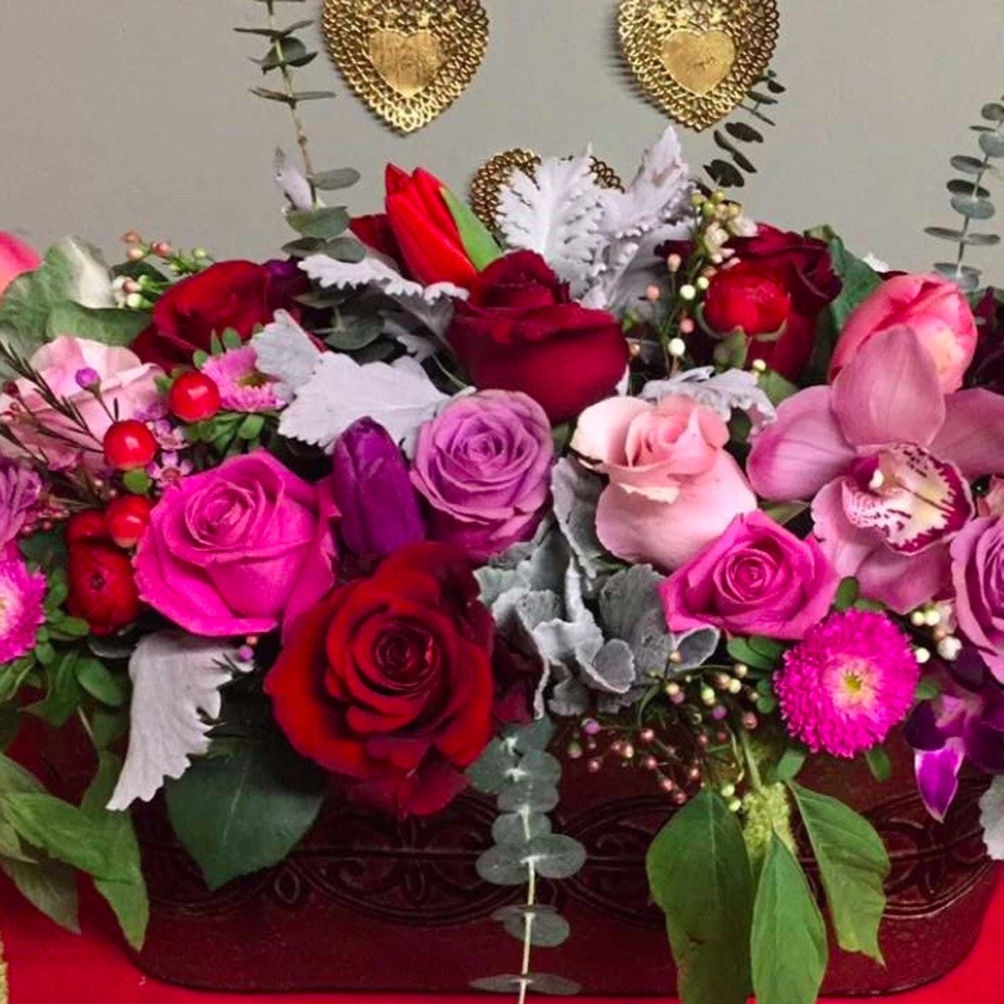 This Beautiful design of mix color roses, tulips. ranunculus, cymbidium orchids, and