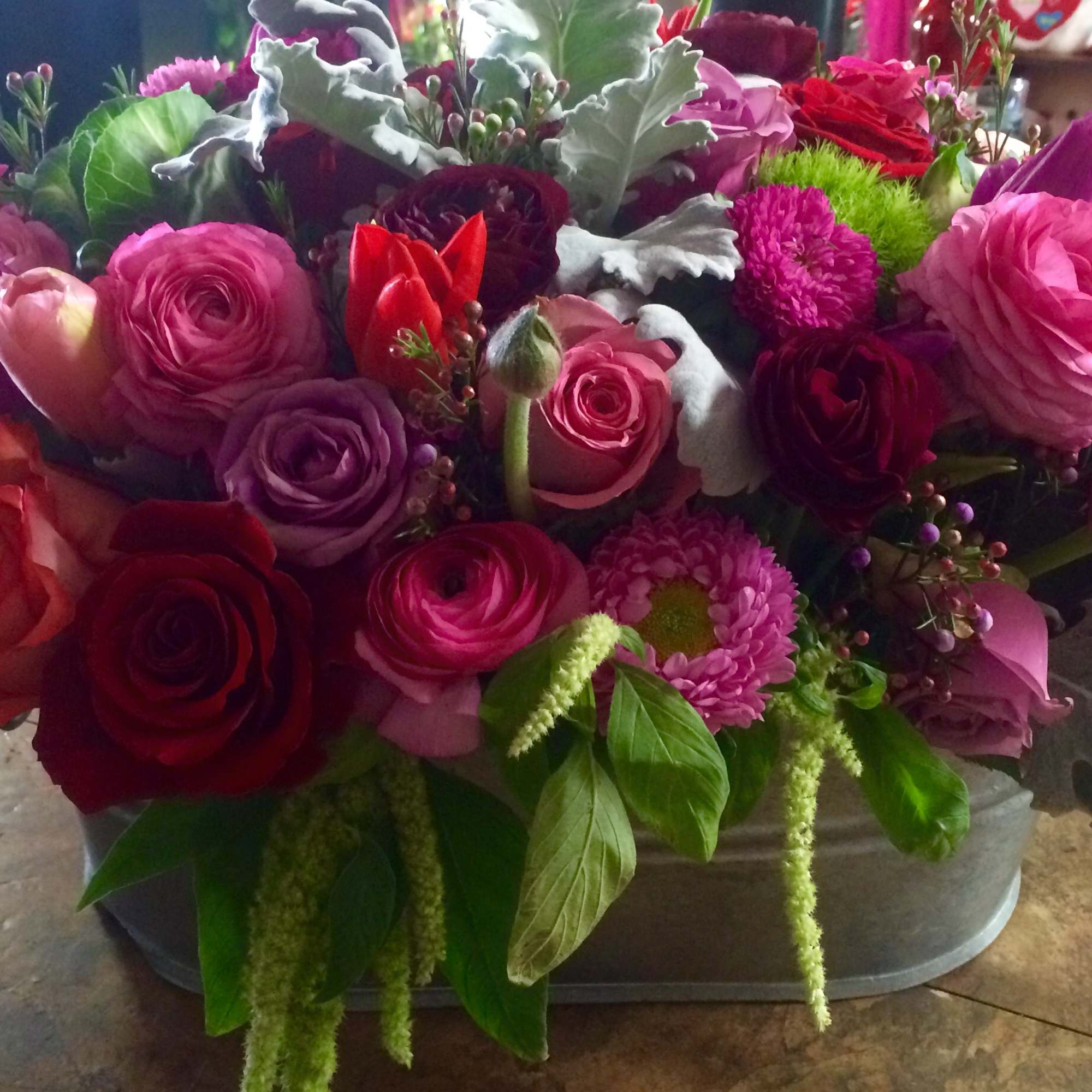 This Beautiful design of mix color roses, tulips. ranunculus, cymbidium orchids, and