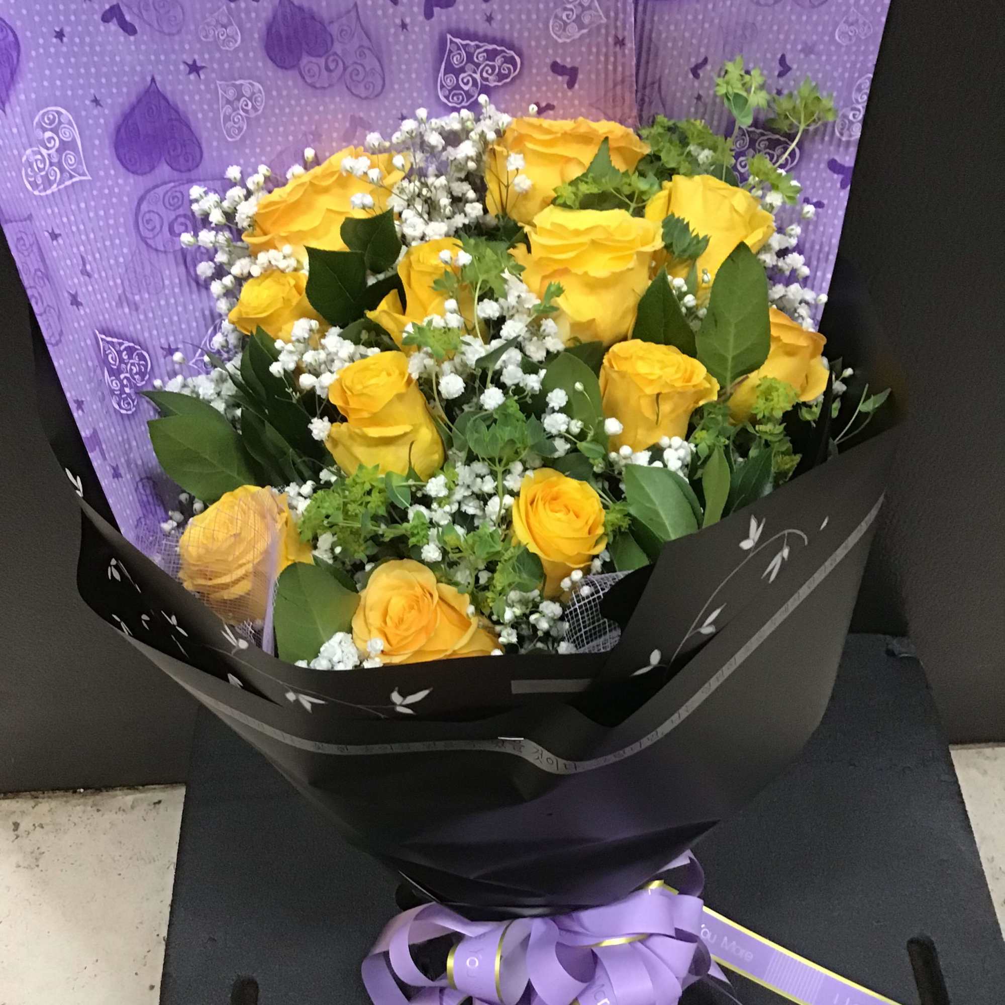 yellow roses with baby breath and filler wrapping with the lavender and