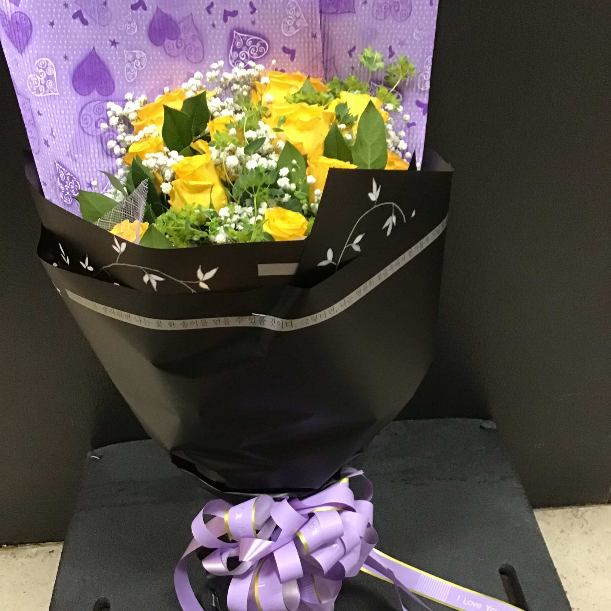 yellow roses with baby breath and filler wrapping with the lavender and