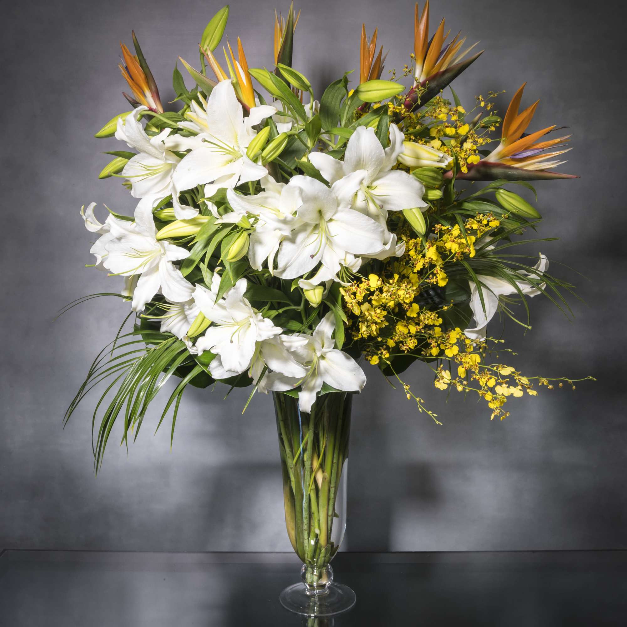 Imported White Lilies, bird of paradise and  dancing lady orchids which