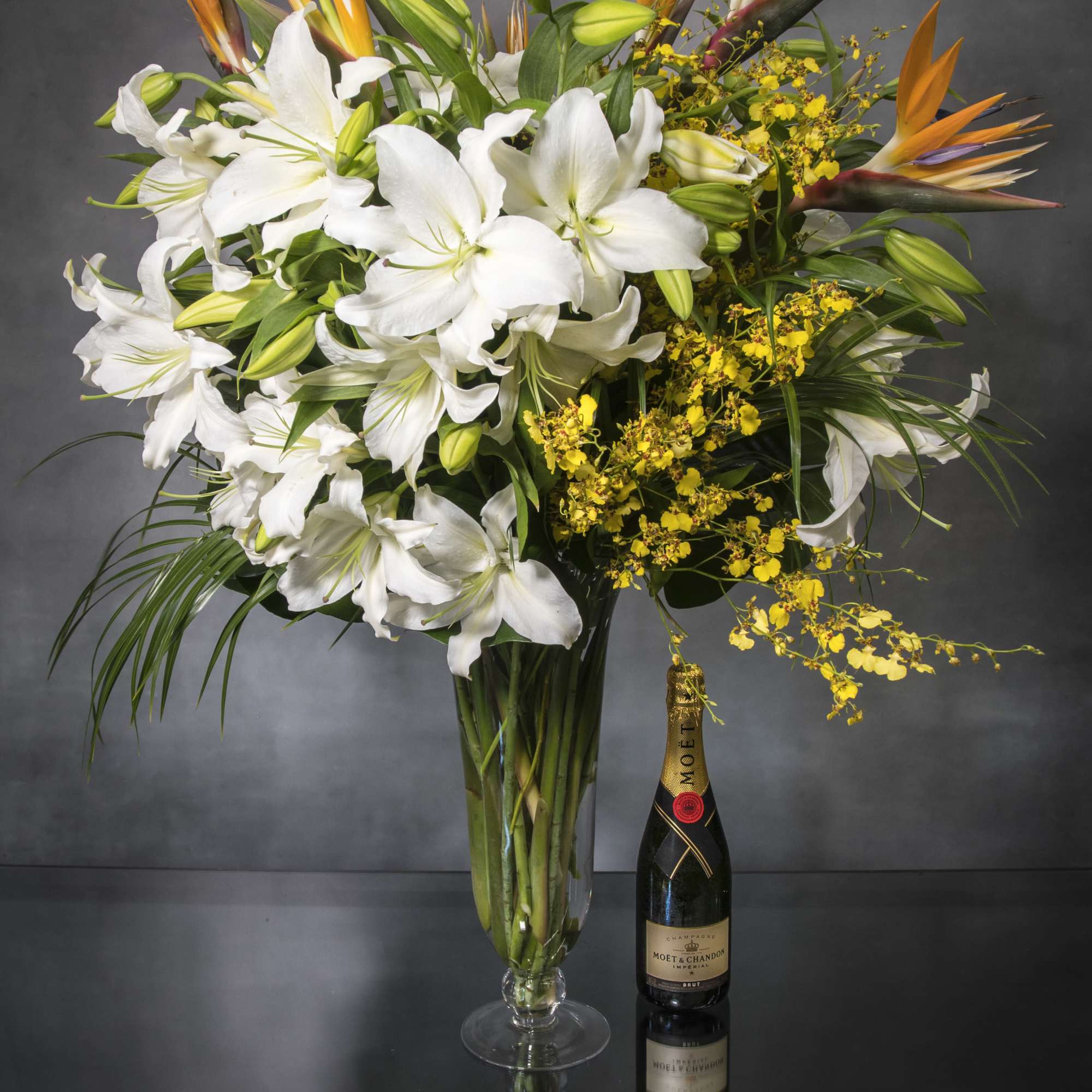 Imported White Lilies, bird of paradise and  dancing lady orchids which