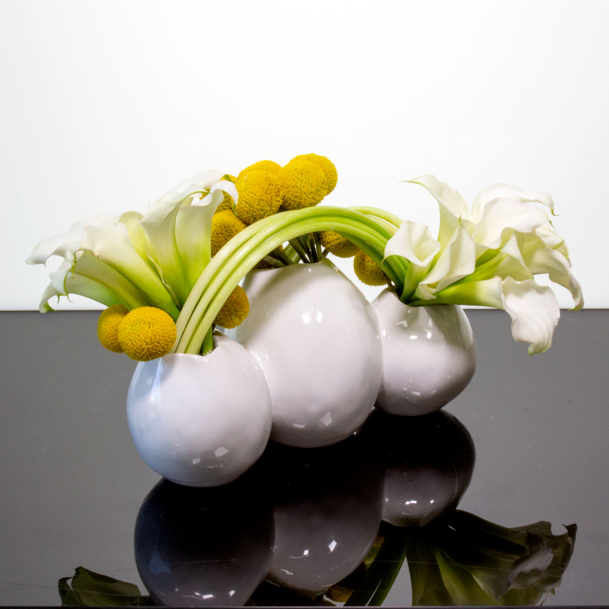A modern floral sculpture of 20 stems of white Calla Lilies and