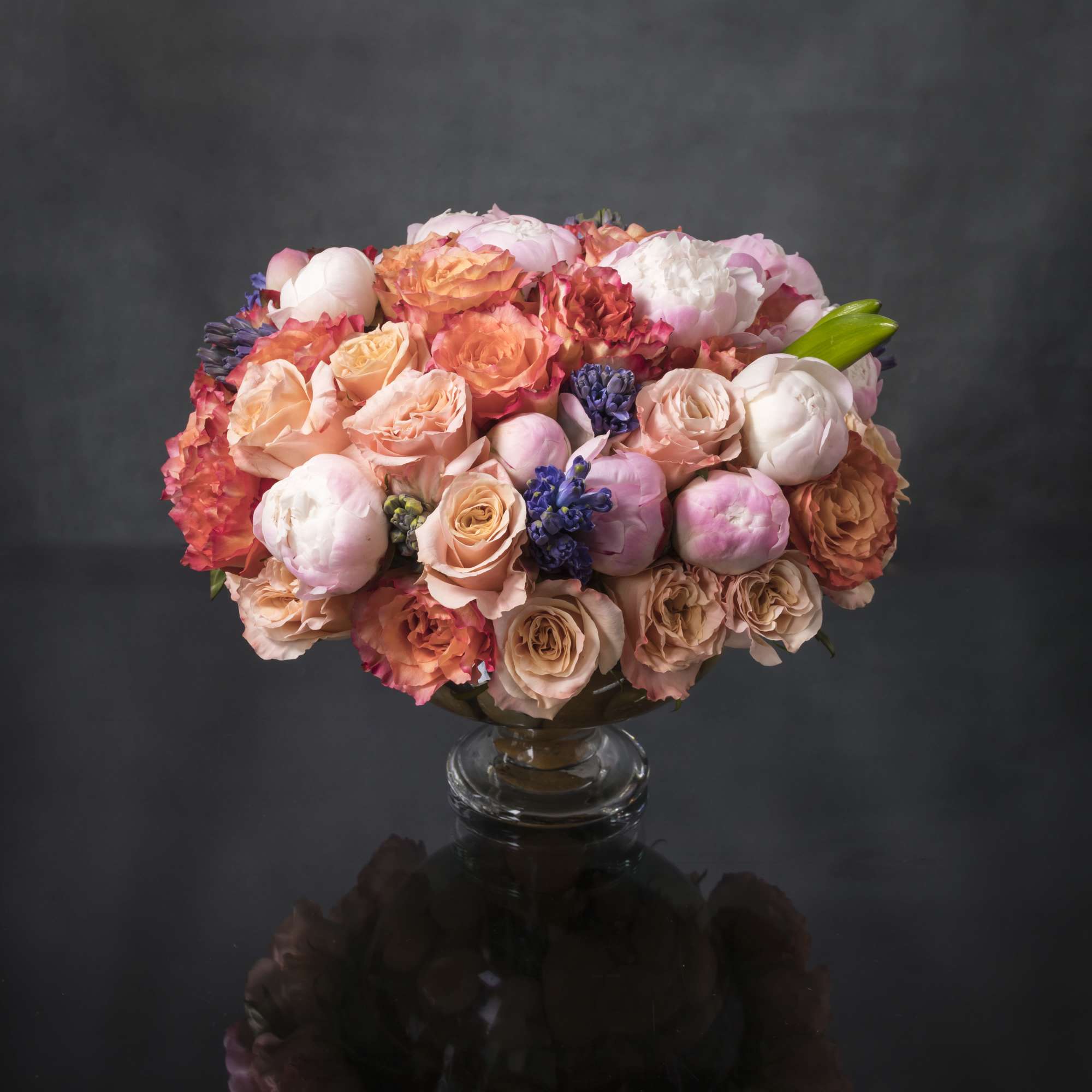 Luscious spring-colored blooms highlight this lovely and abundant arrangement. Gorgeous coral and