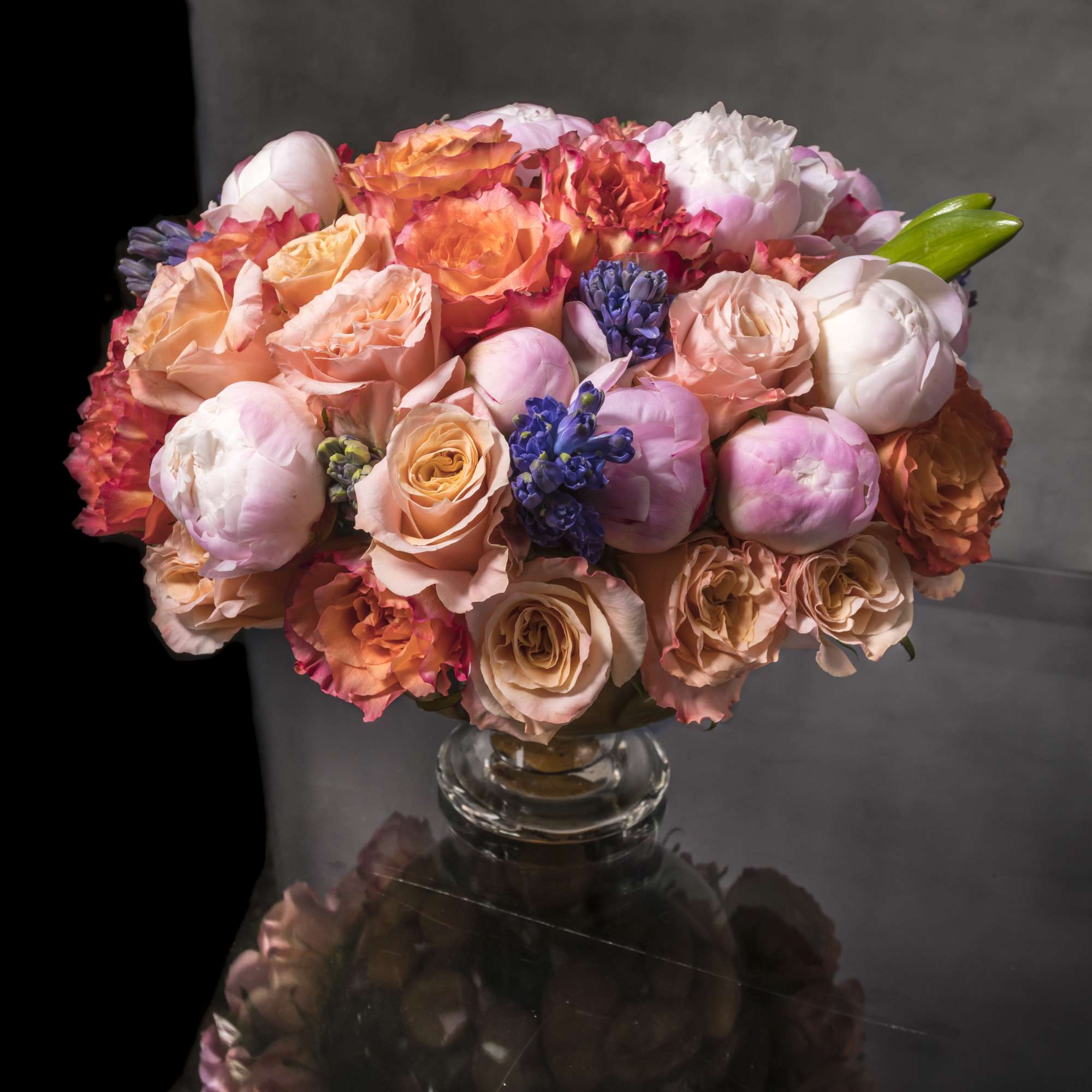 Luscious spring-colored blooms highlight this lovely and abundant arrangement. Gorgeous coral and