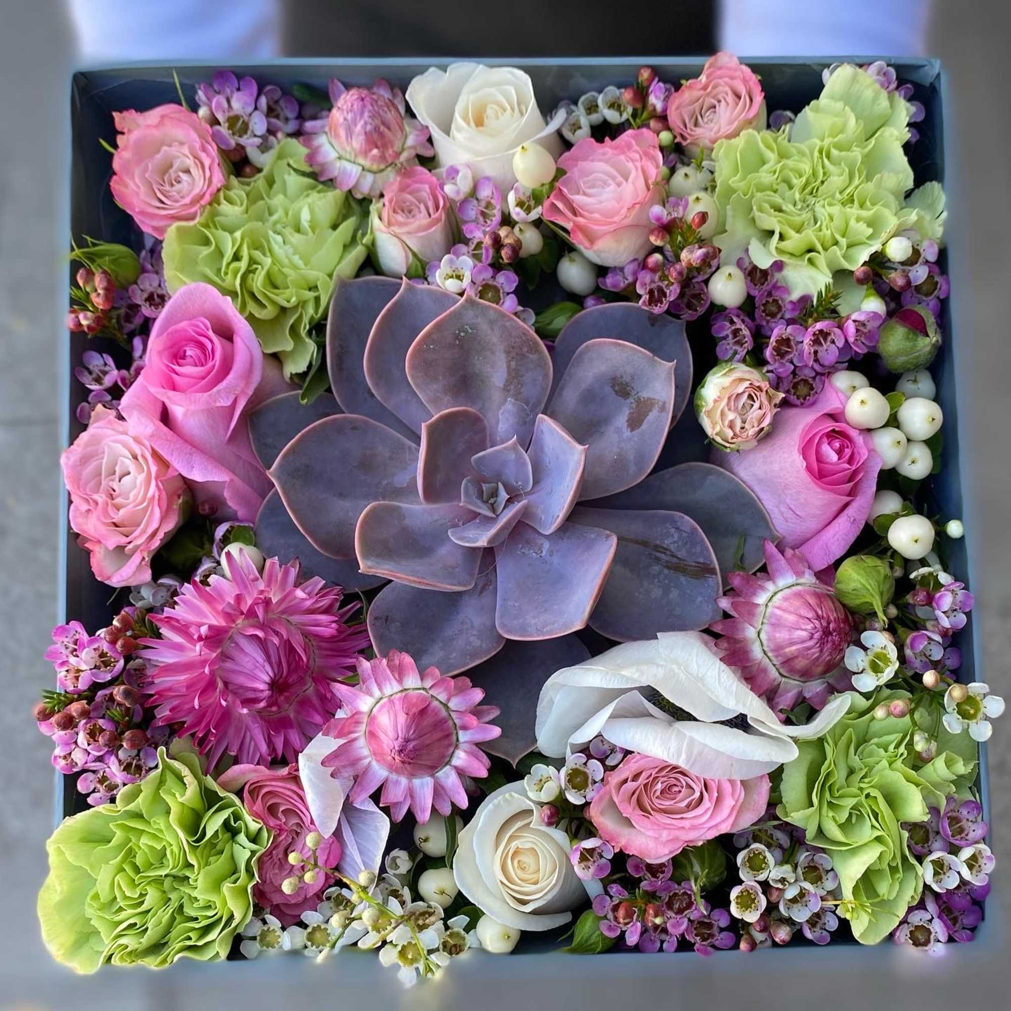 Mix flowers with a succulent arranged in a box. 
Box color may