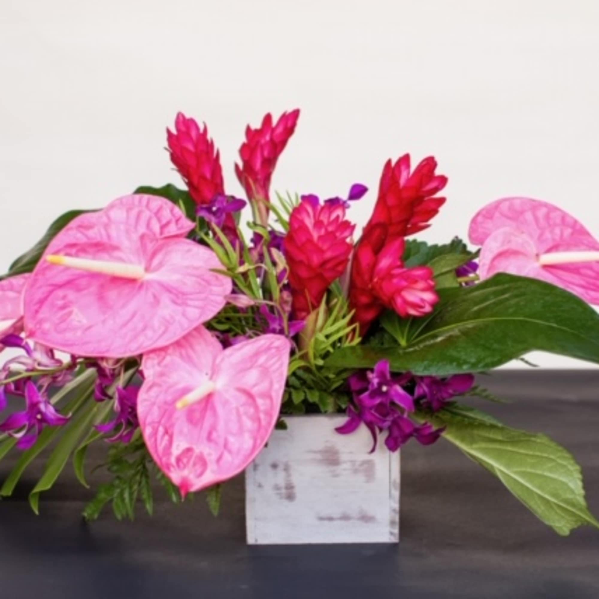 A vibrant arrangement designed with jewel&nbsp;tone&nbsp;tropical blooms and foliage. &nbsp;Modern in it&#039;s